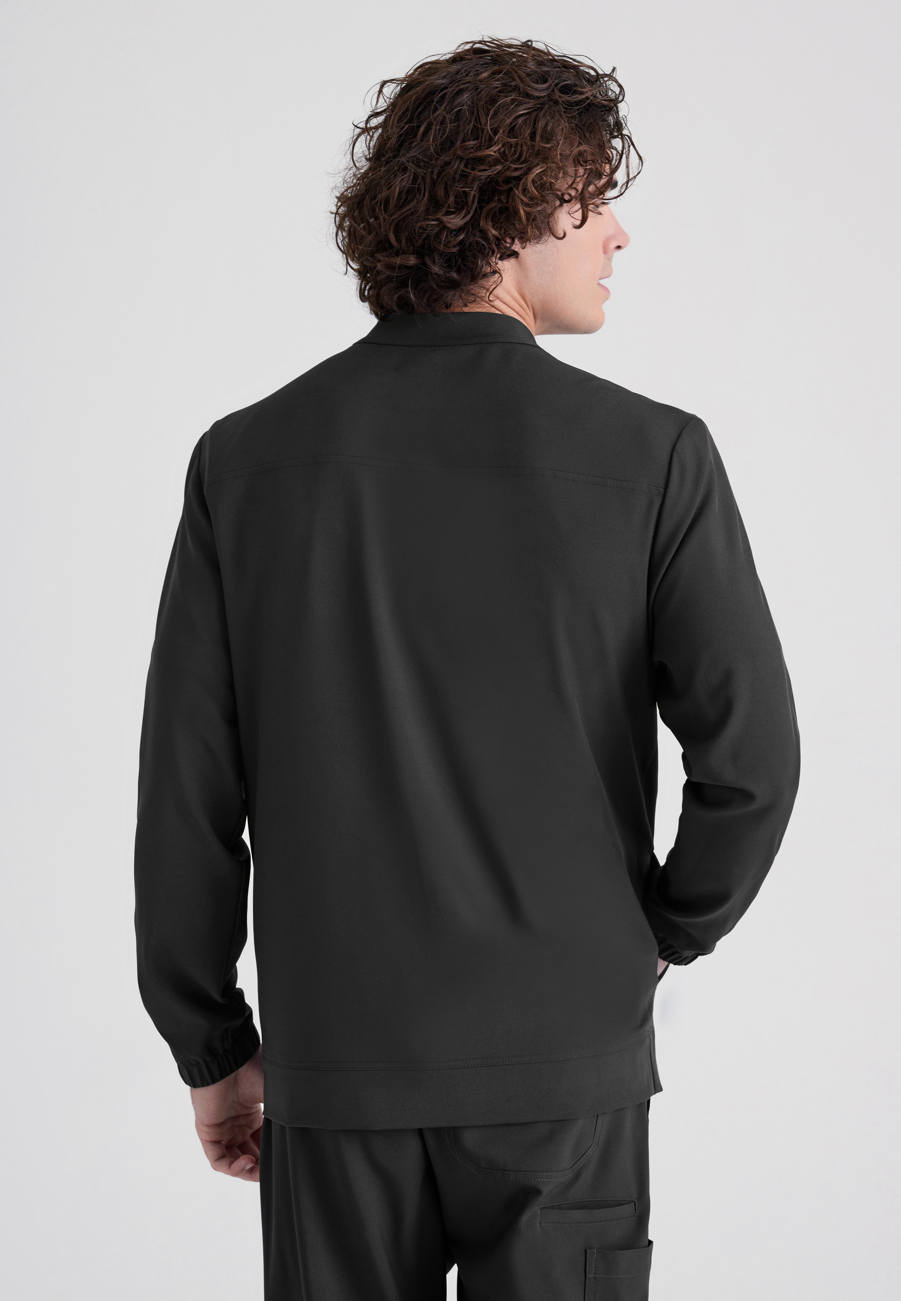 Back View of the Cycle 3-Pocket Crewneck Ciclo® Scrub Jacket in Black from Grey's Anatomy™ by Barco Evolve
