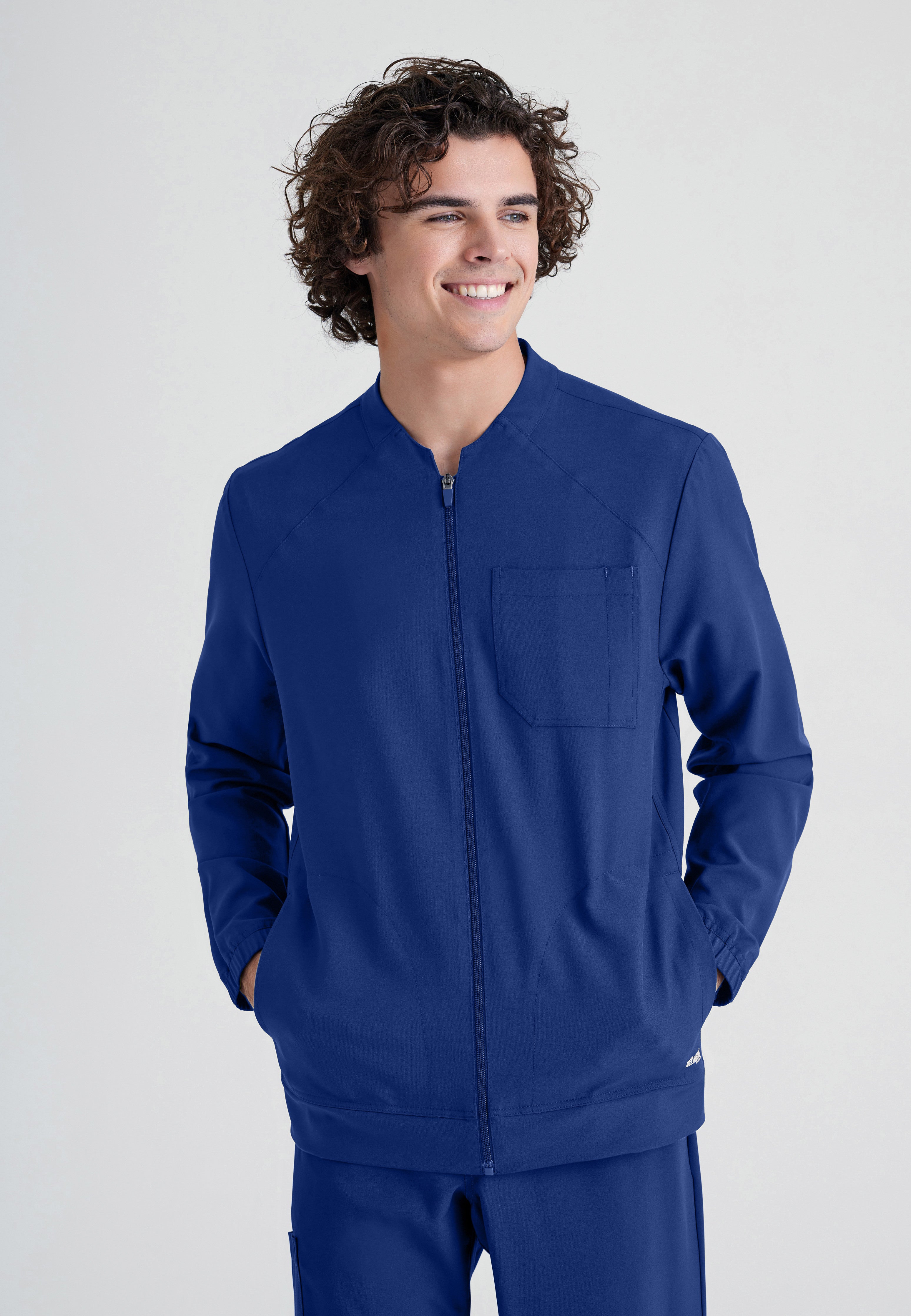 Front View of the Cycle 3-Pocket Crewneck Ciclo® Scrub Jacket in Indigo from Grey's Anatomy™ by Barco Evolve