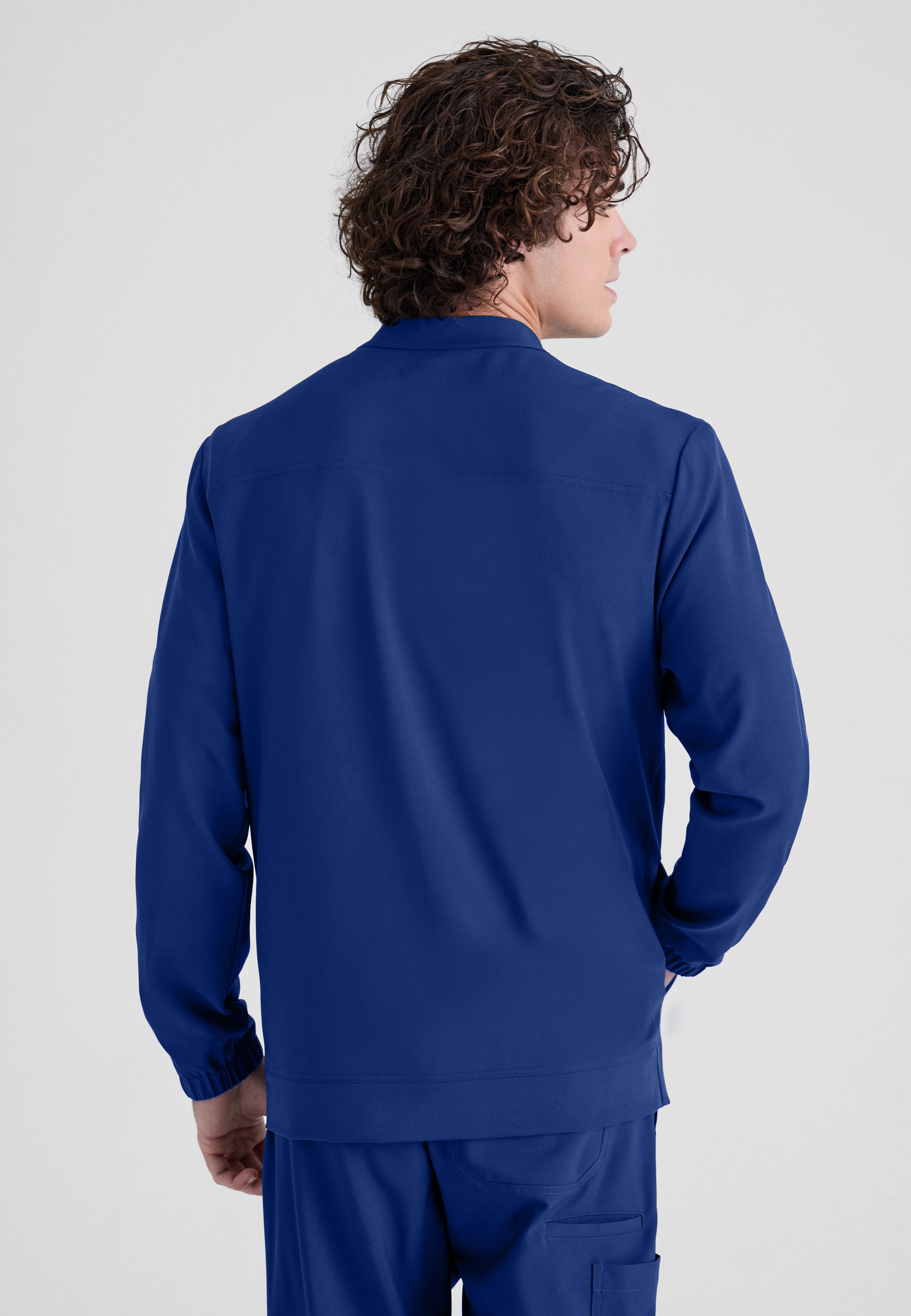 Back View of the Cycle 3-Pocket Crewneck Ciclo® Scrub Jacket in Indigo from Grey's Anatomy™ by Barco Evolve