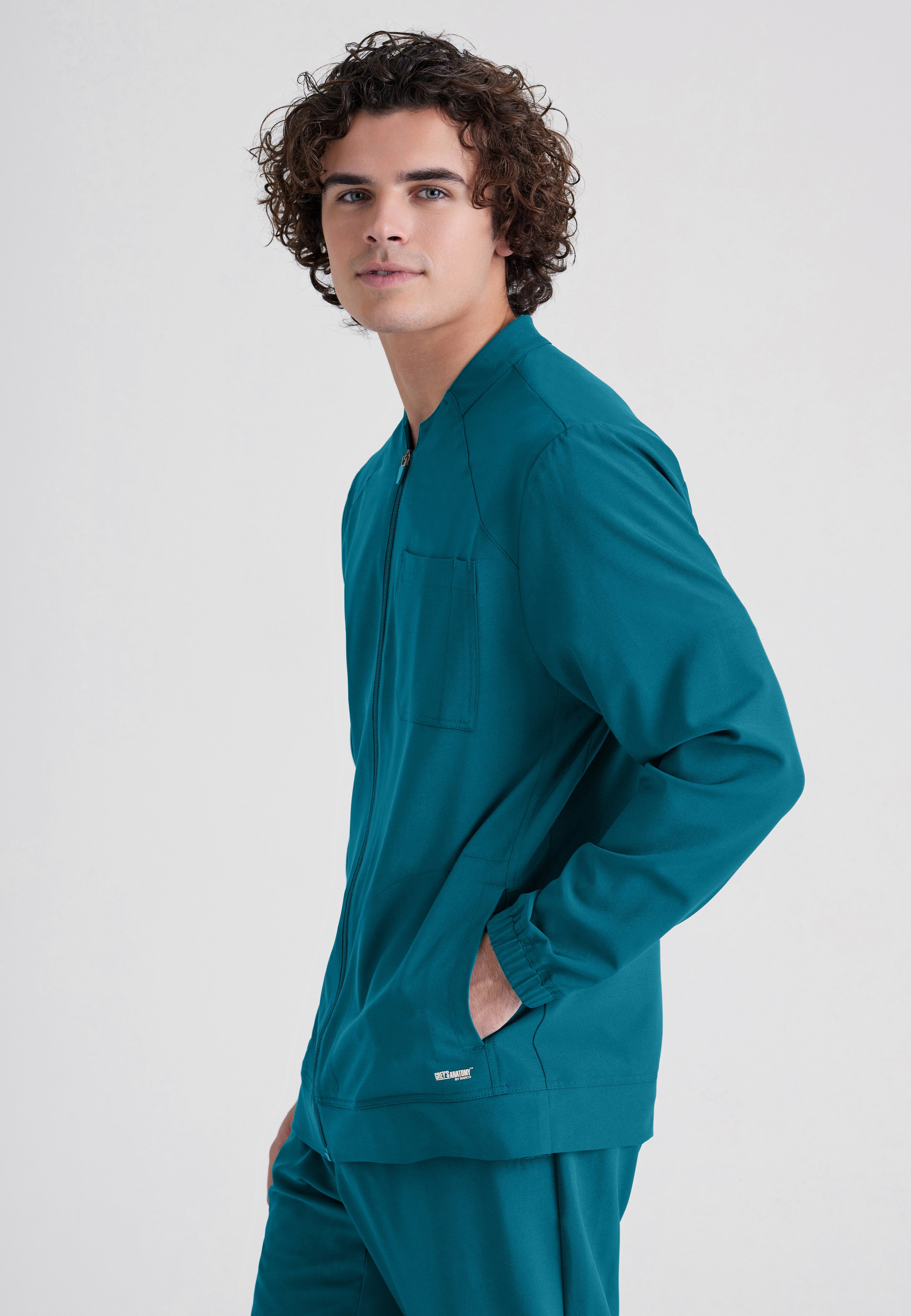 Side View of the Cycle 3-Pocket Crewneck Ciclo® Scrub Jacket in Bahama from Grey's Anatomy™ by Barco Evolve