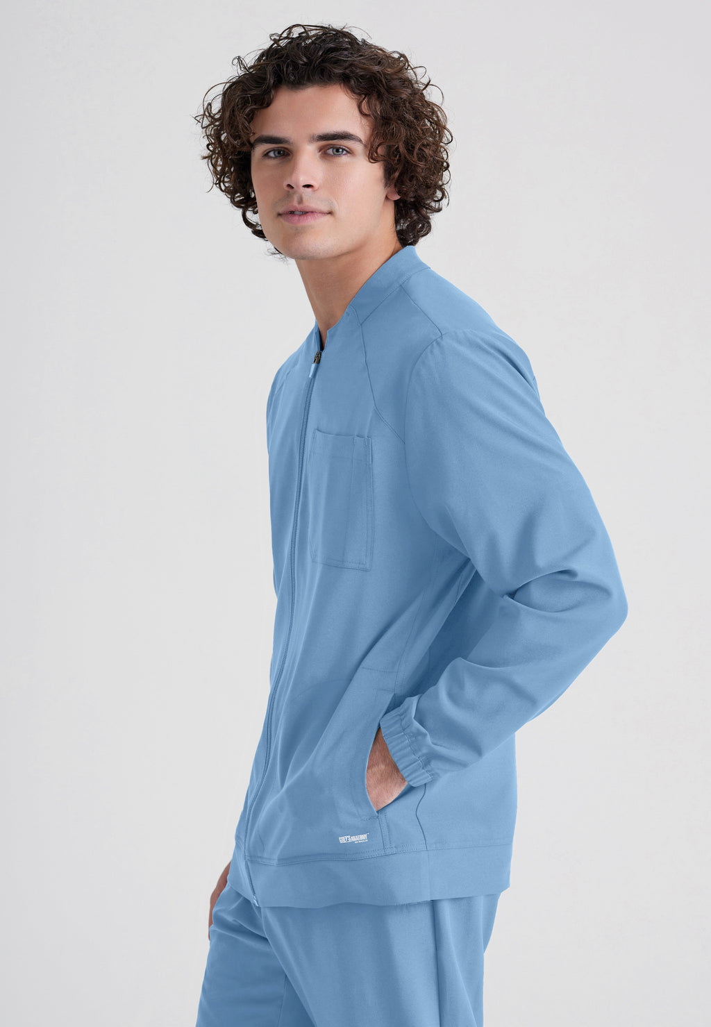 Side View of the Cycle 3-Pocket Crewneck Ciclo® Scrub Jacket in Ciel Blue from Grey's Anatomy™ by Barco Evolve