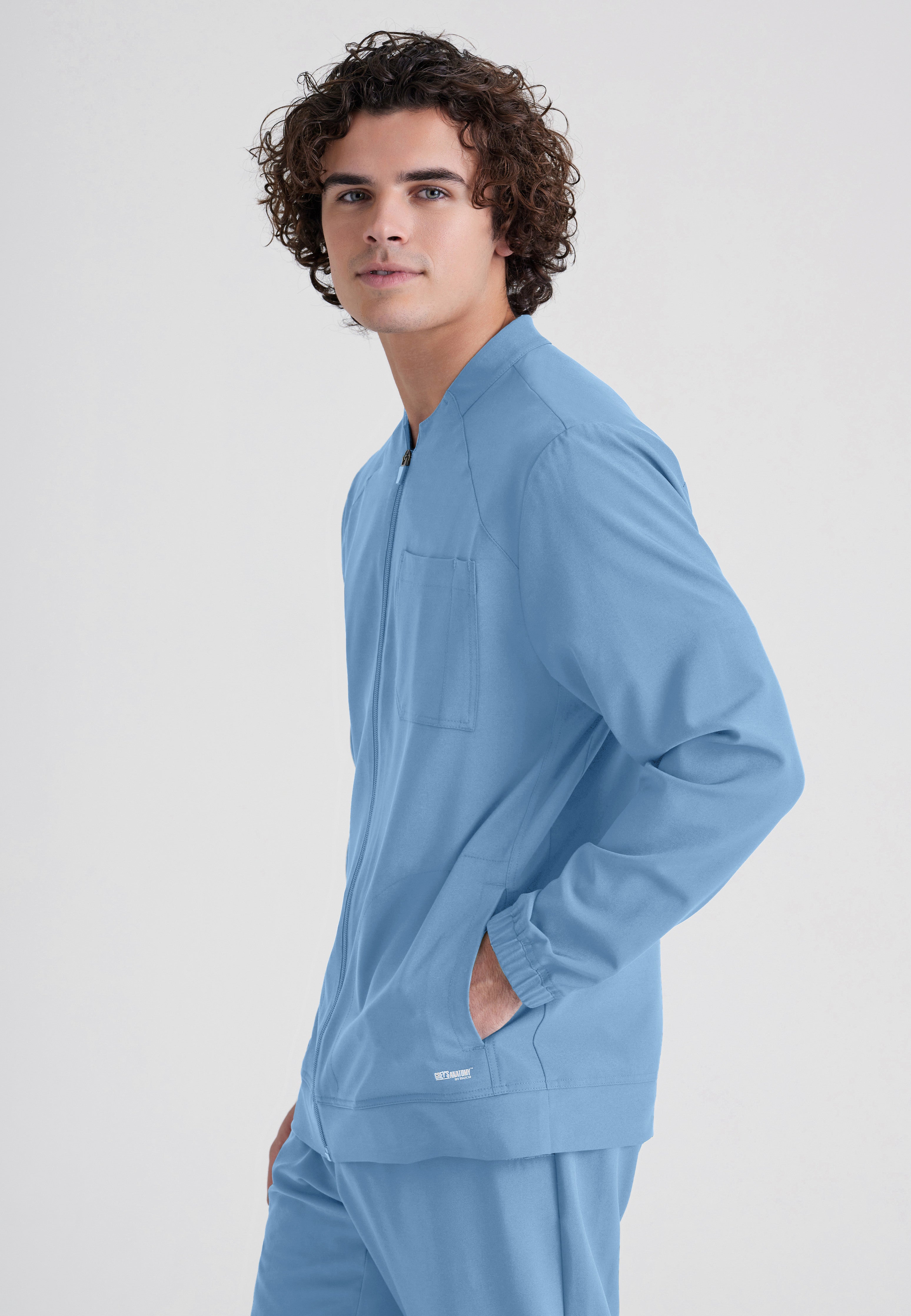 Side View of the Cycle 3-Pocket Crewneck Ciclo® Scrub Jacket in Ciel Blue from Grey's Anatomy™ by Barco Evolve