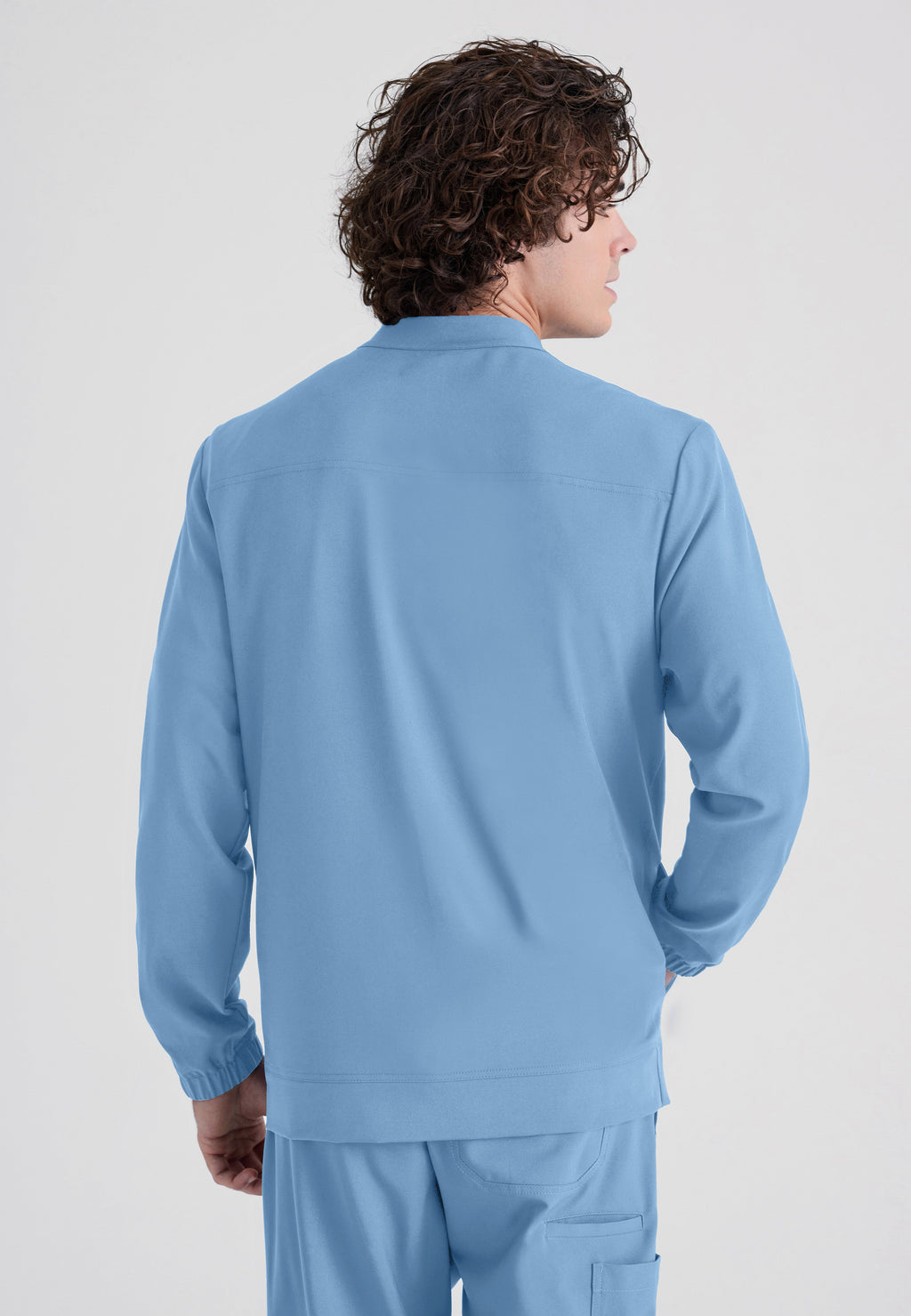 Back View of the Cycle 3-Pocket Crewneck Ciclo® Scrub Jacket in Ciel Blue from Grey's Anatomy™ by Barco Evolve