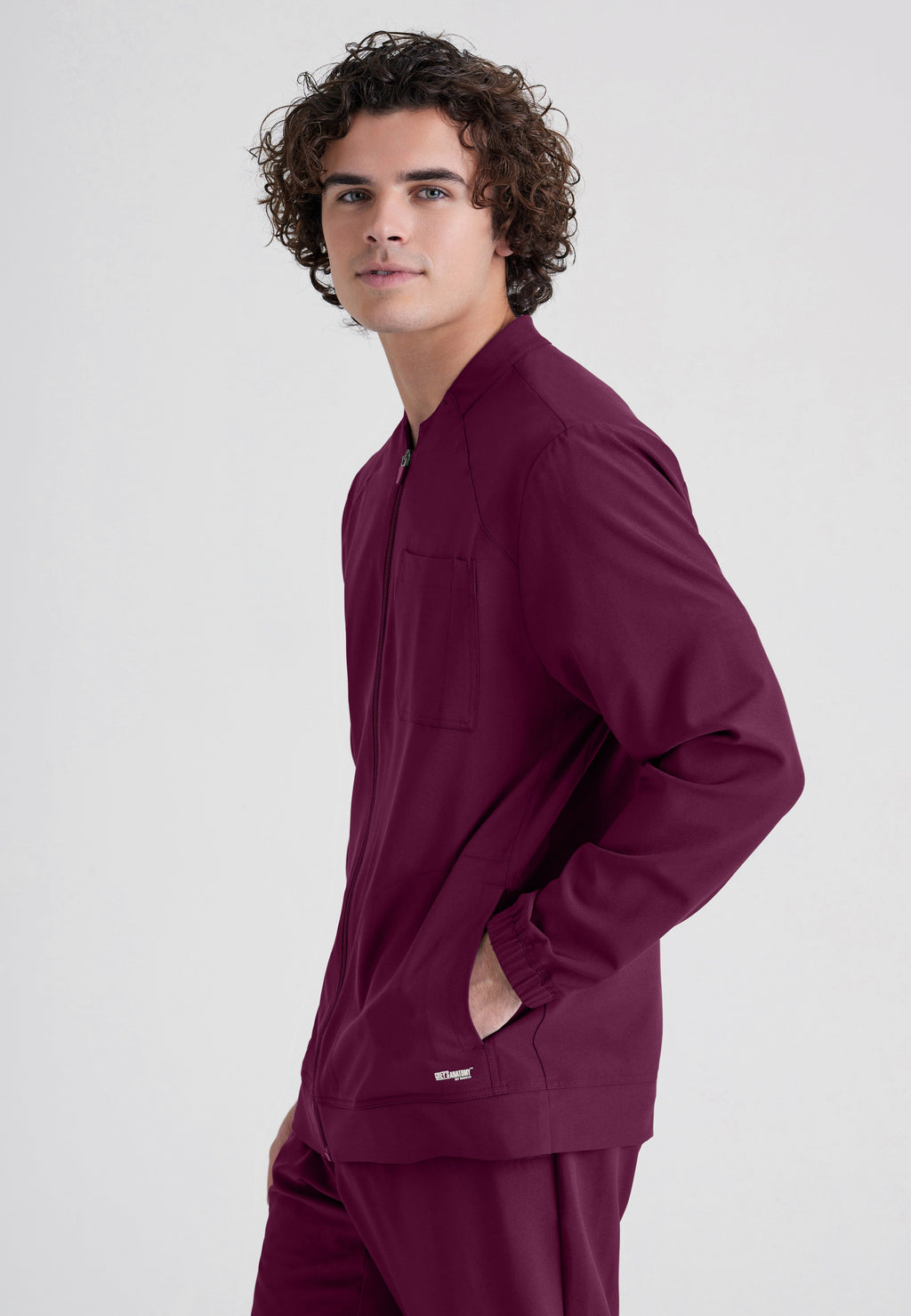 Side View of the Cycle 3-Pocket Crewneck Ciclo® Scrub Jacket in Wine from Grey's Anatomy™ by Barco Evolve