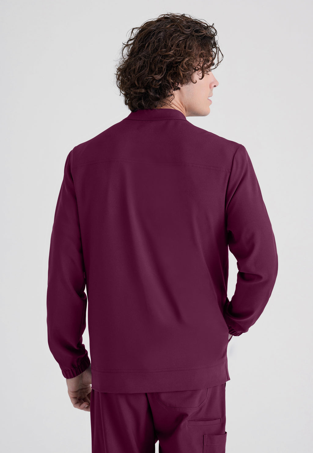 Back View of the Cycle 3-Pocket Crewneck Ciclo® Scrub Jacket in Wine from Grey's Anatomy™ by Barco Evolve