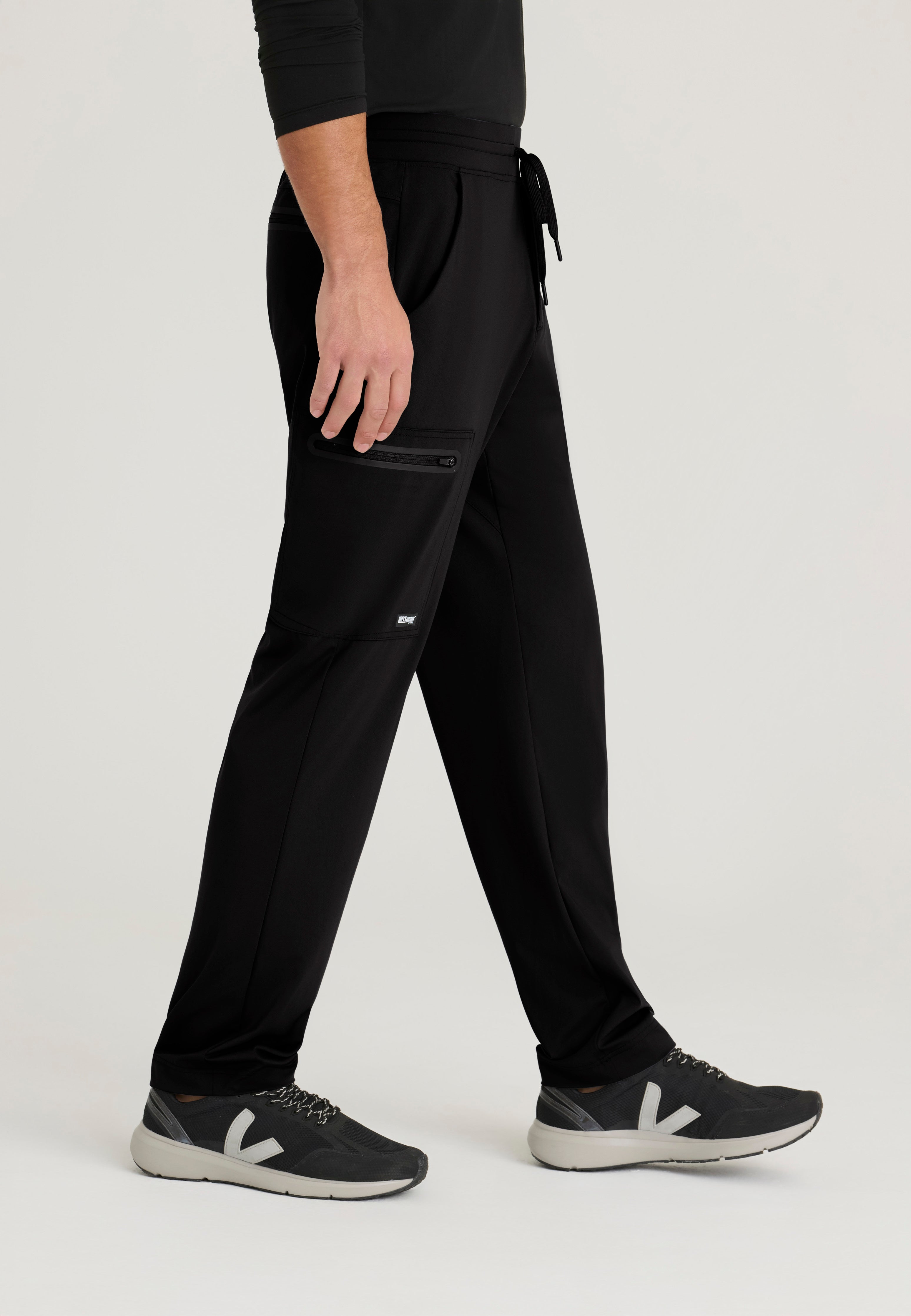Side View of the Focus 4-Pocket Slim Straight Knit Pant in Black from Grey's Anatomy™ by Barco Knit Stretch