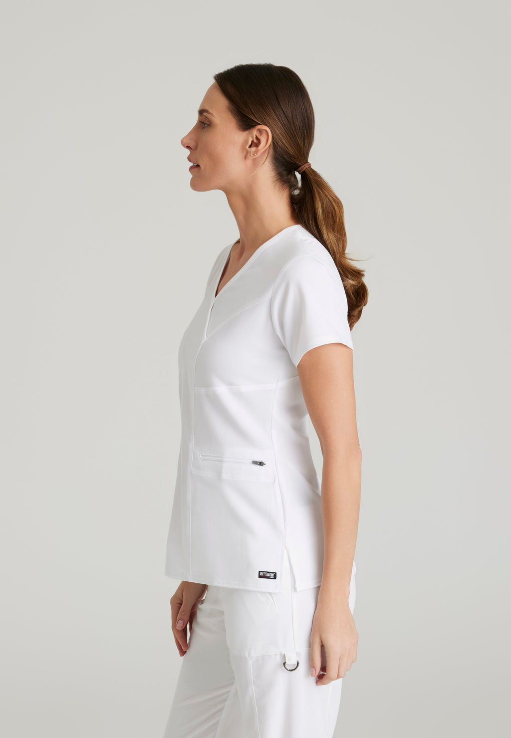 Side View of the Kim 3-Pocket Crossover V-Neck Scrub Top in White from Grey's Anatomy™ by Barco Spandex Stretch