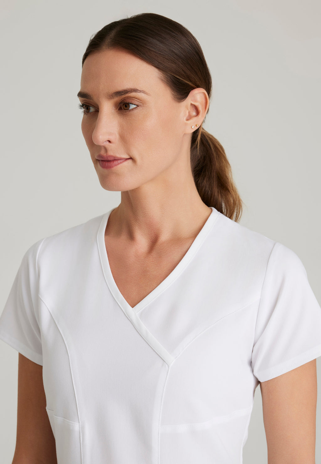 Detail Shot of the Kim 3-Pocket Crossover V-Neck Scrub Top in White from Grey's Anatomy™ by Barco Spandex Stretch