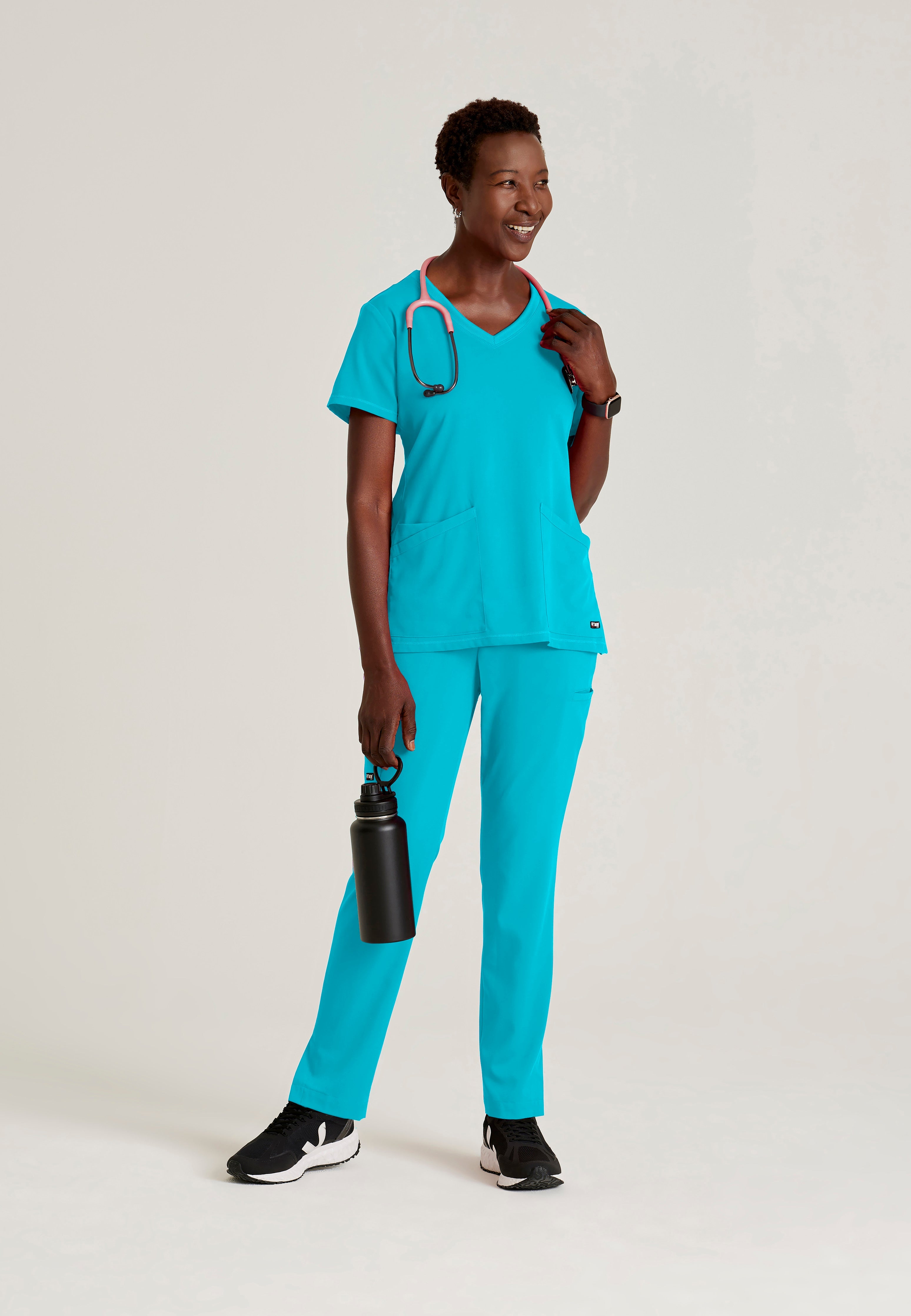 Full Body View of the Serena 3-Pocket Curved V-Neck Scrub Top in Teal from Grey's Anatomy™ by Barco Spandex Stretch