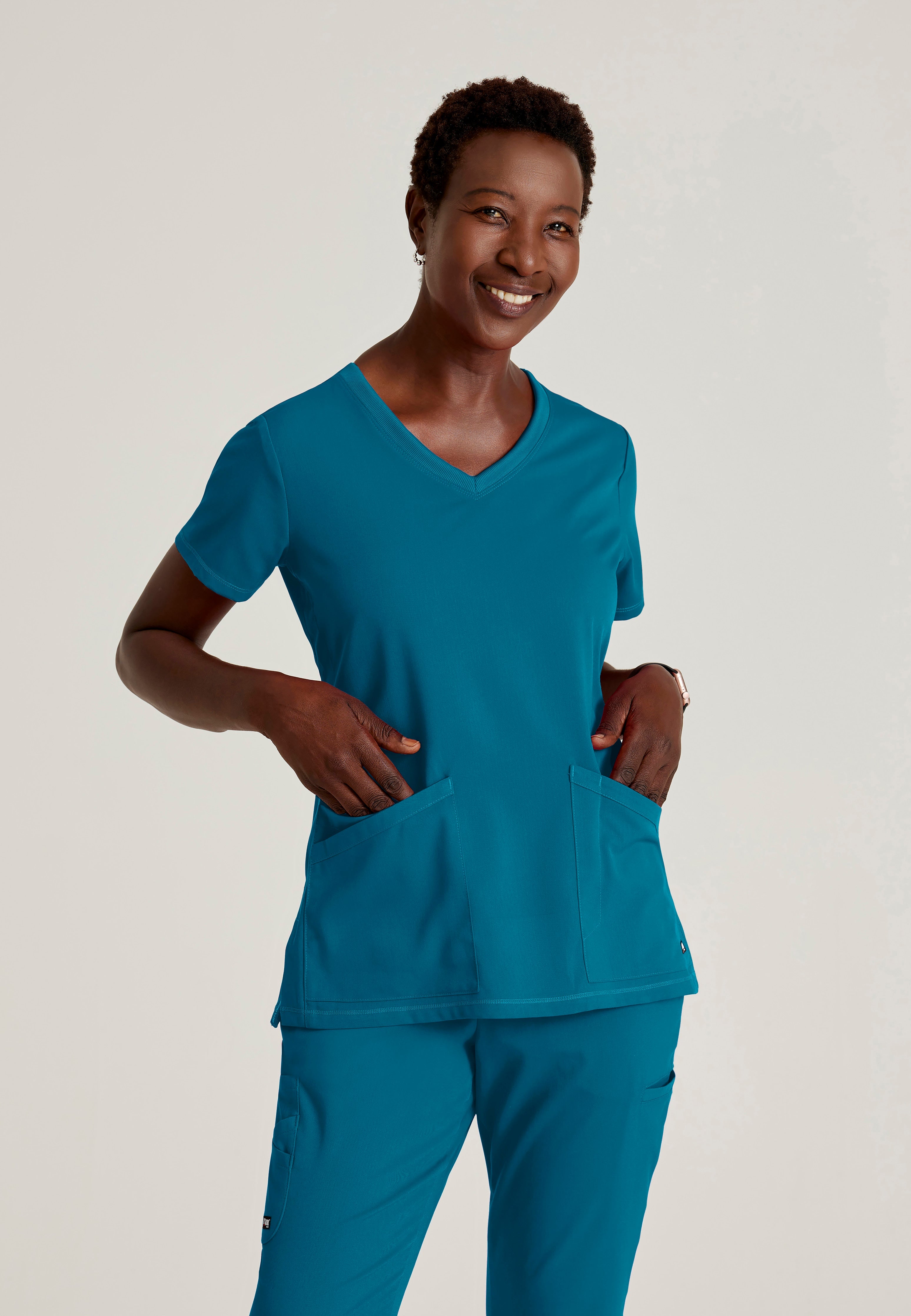 Front View of the Serena 3-Pocket Curved V-Neck Scrub Top in Bahama from Grey's Anatomy™ by Barco Spandex Stretch