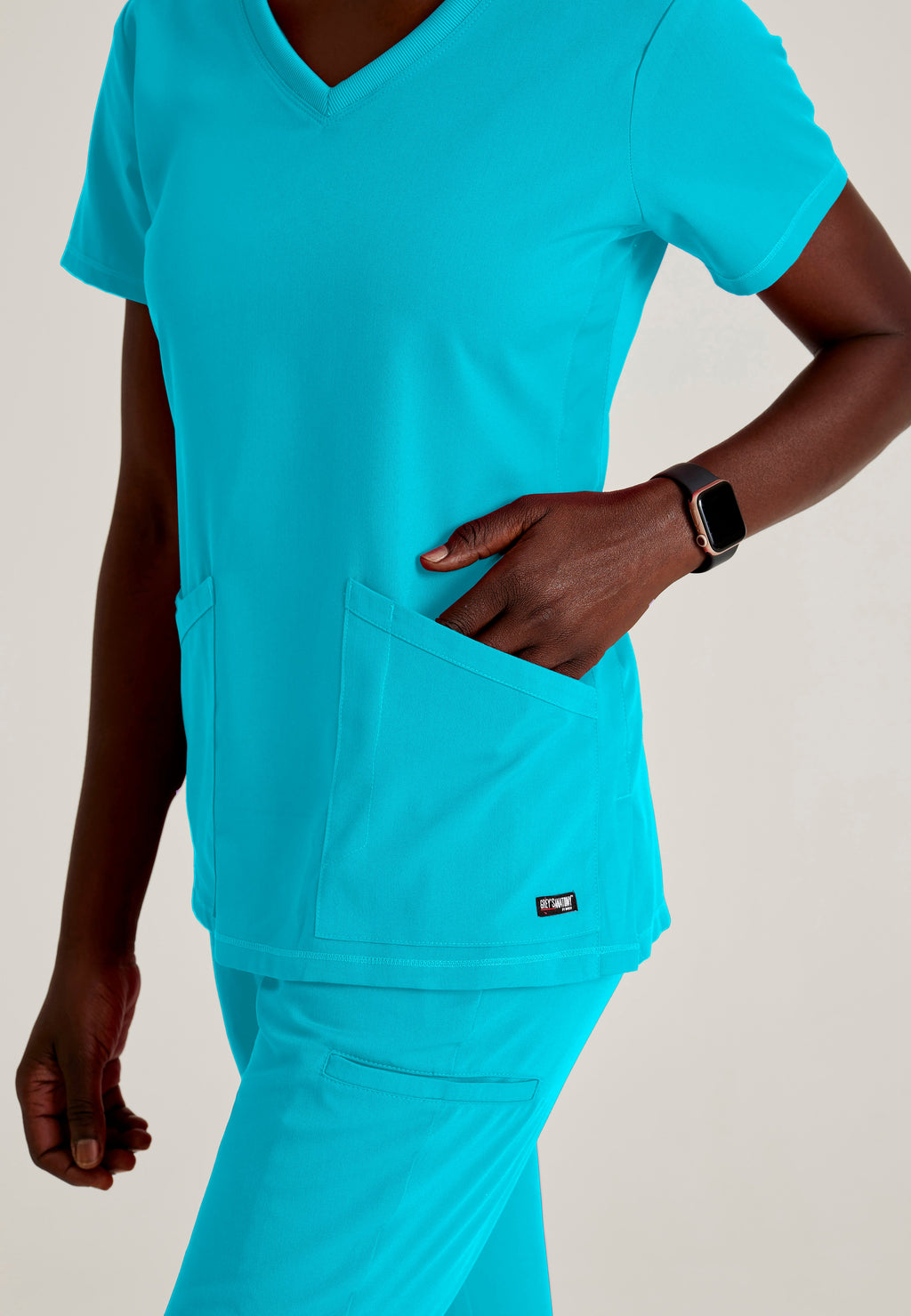 Detail Shot of the Serena 3-Pocket Curved V-Neck Scrub Top in Teal from Grey's Anatomy™ by Barco Spandex Stretch