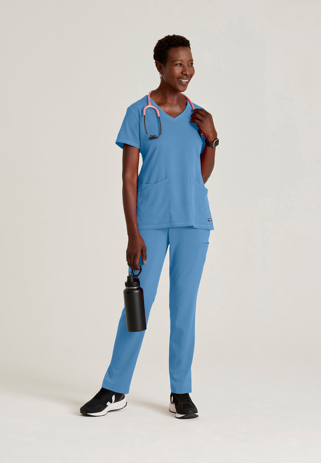 Full Body View of the Serena 3-Pocket Curved V-Neck Scrub Top in Ciel Blue from Grey's Anatomy™ by Barco Spandex Stretch