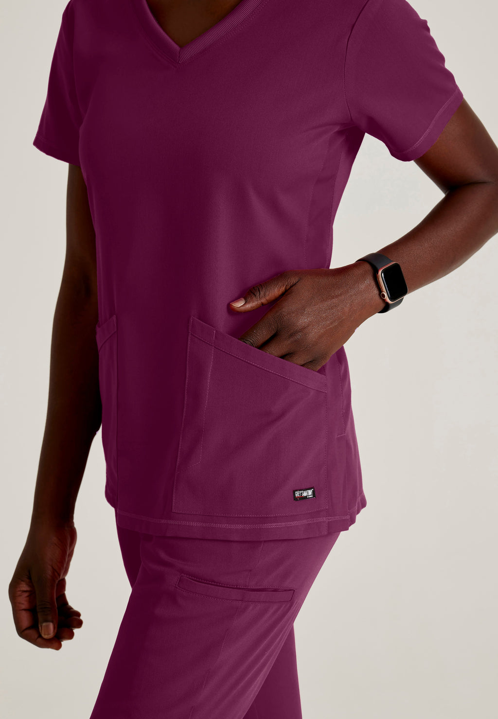 Detail Shot of the Serena 3-Pocket Curved V-Neck Scrub Top in Wine from Grey's Anatomy™ by Barco Spandex Stretch