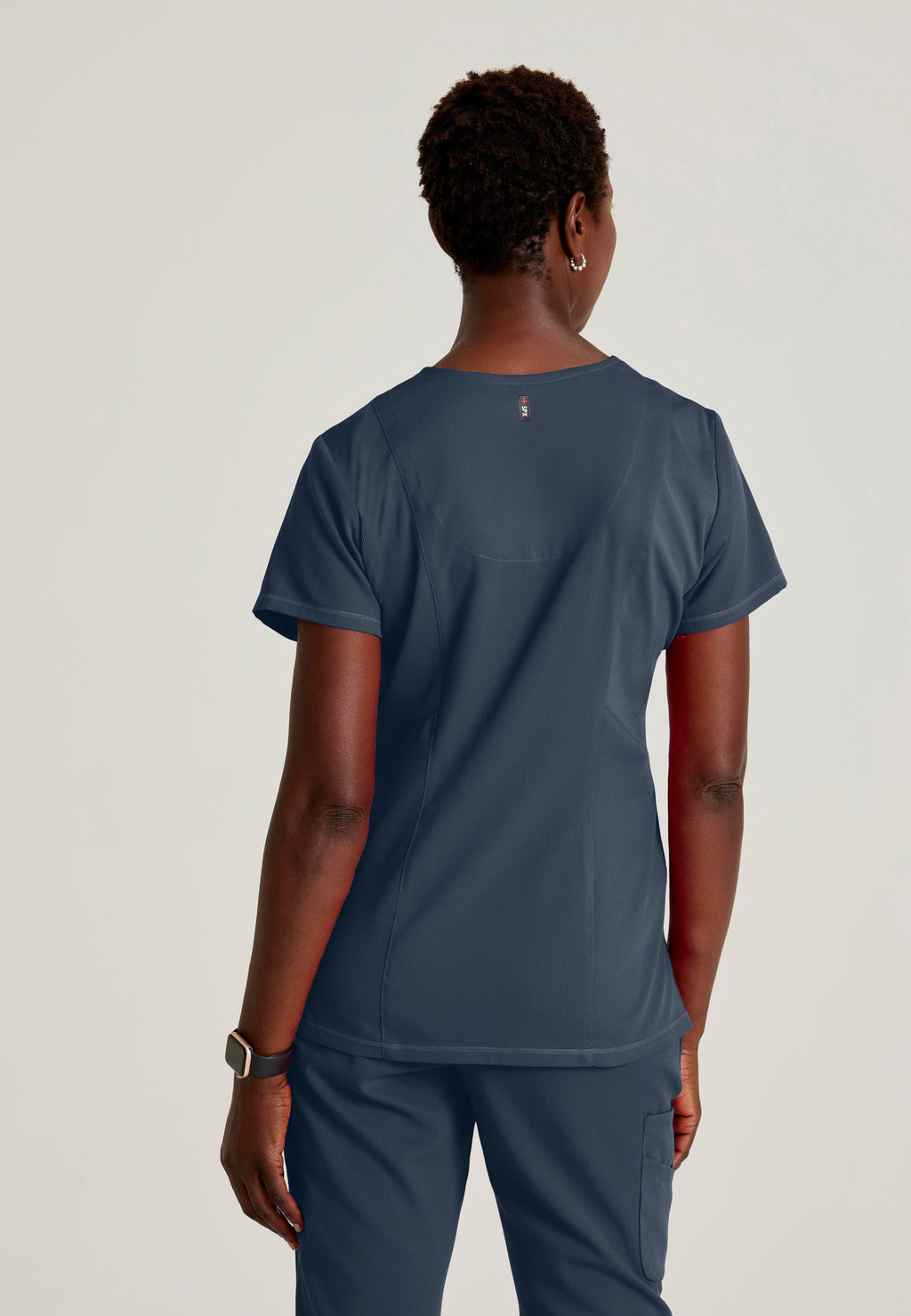 Back View of the Serena 3-Pocket Curved V-Neck Scrub Top in Steel from Grey's Anatomy™ by Barco Spandex Stretch