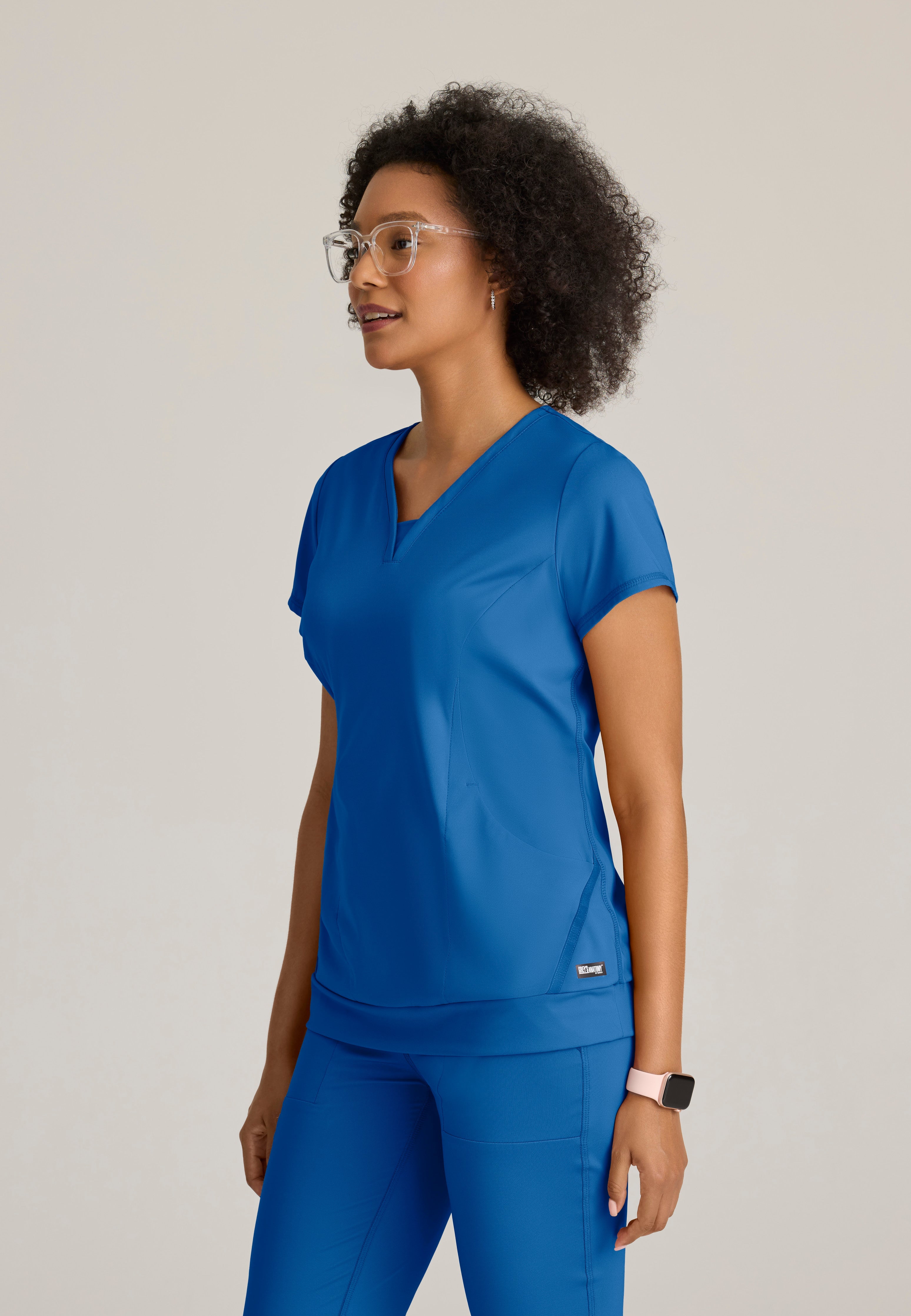 Side View of the Motivate Curved V-Neck Knit Scrub Top in New Royal from Grey's Anatomy™ by Barco Knit Stretch
