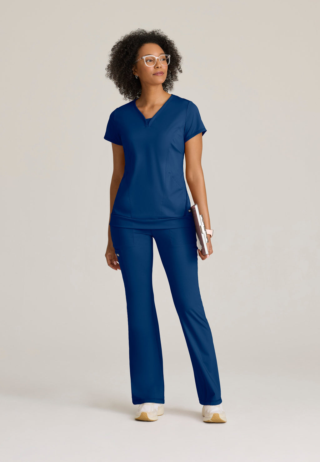 Full Body View of the Motivate Curved V-Neck Knit Scrub Top in Indigo from Grey's Anatomy™ by Barco Knit Stretch