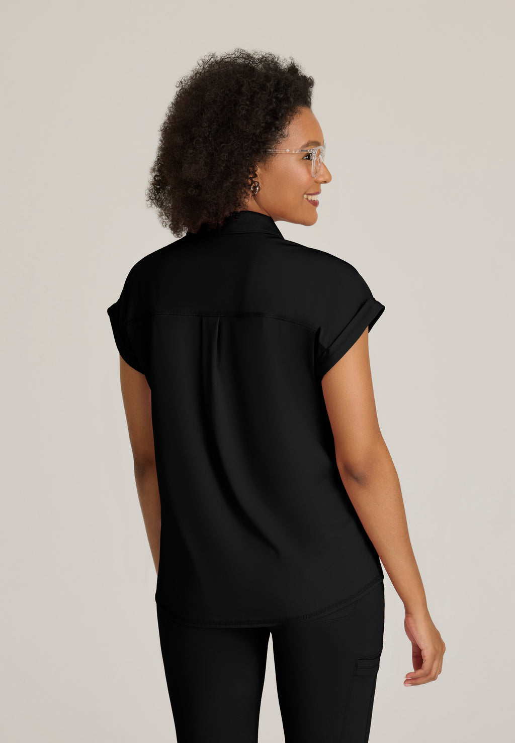 Back View of the Renew Snap Placket Knit Scrub Top in Black from Grey's Anatomy™ by Barco Knit Stretch