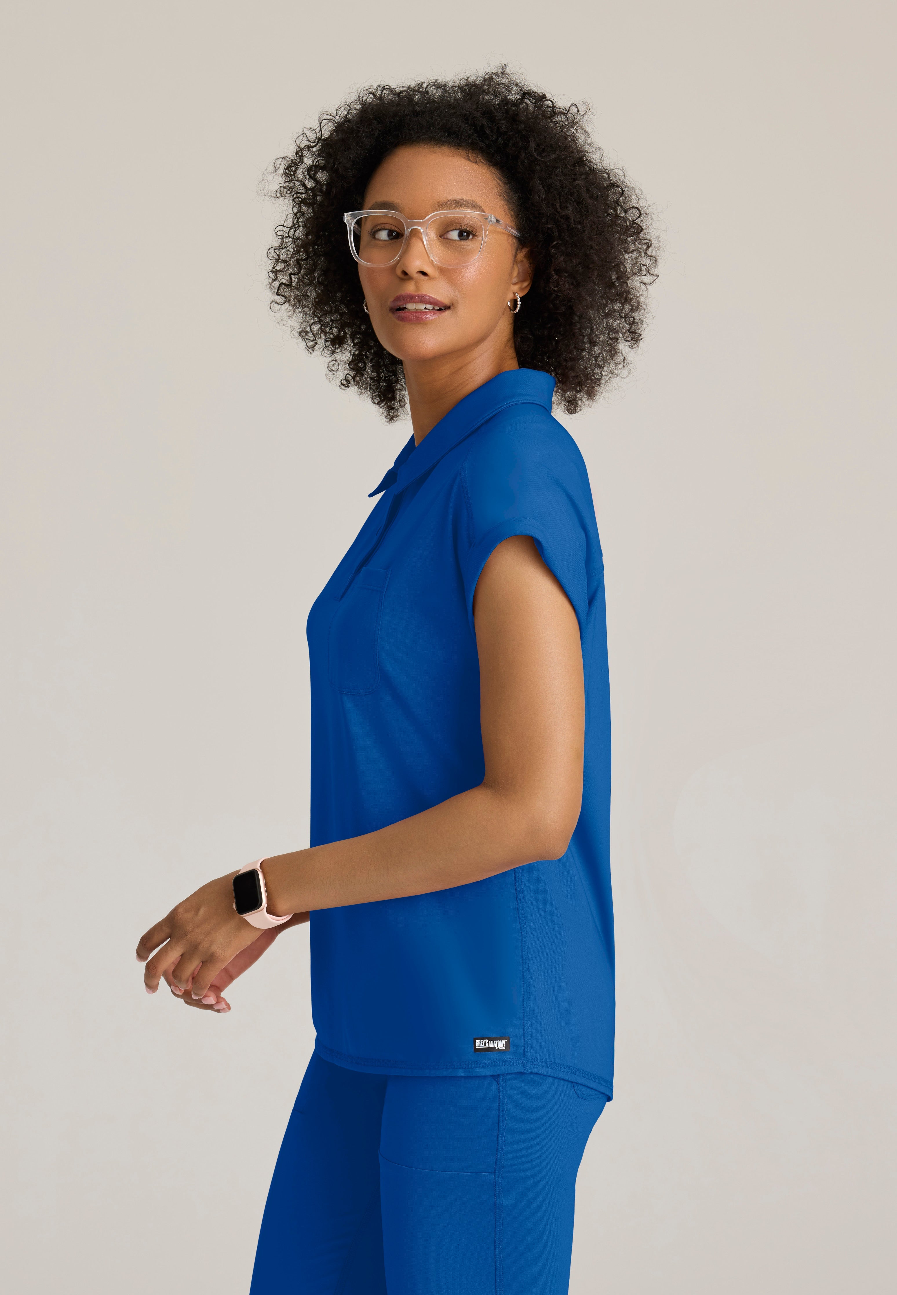 Side View of the Renew Snap Placket Knit Scrub Top in New Royal from Grey's Anatomy™ by Barco Knit Stretch