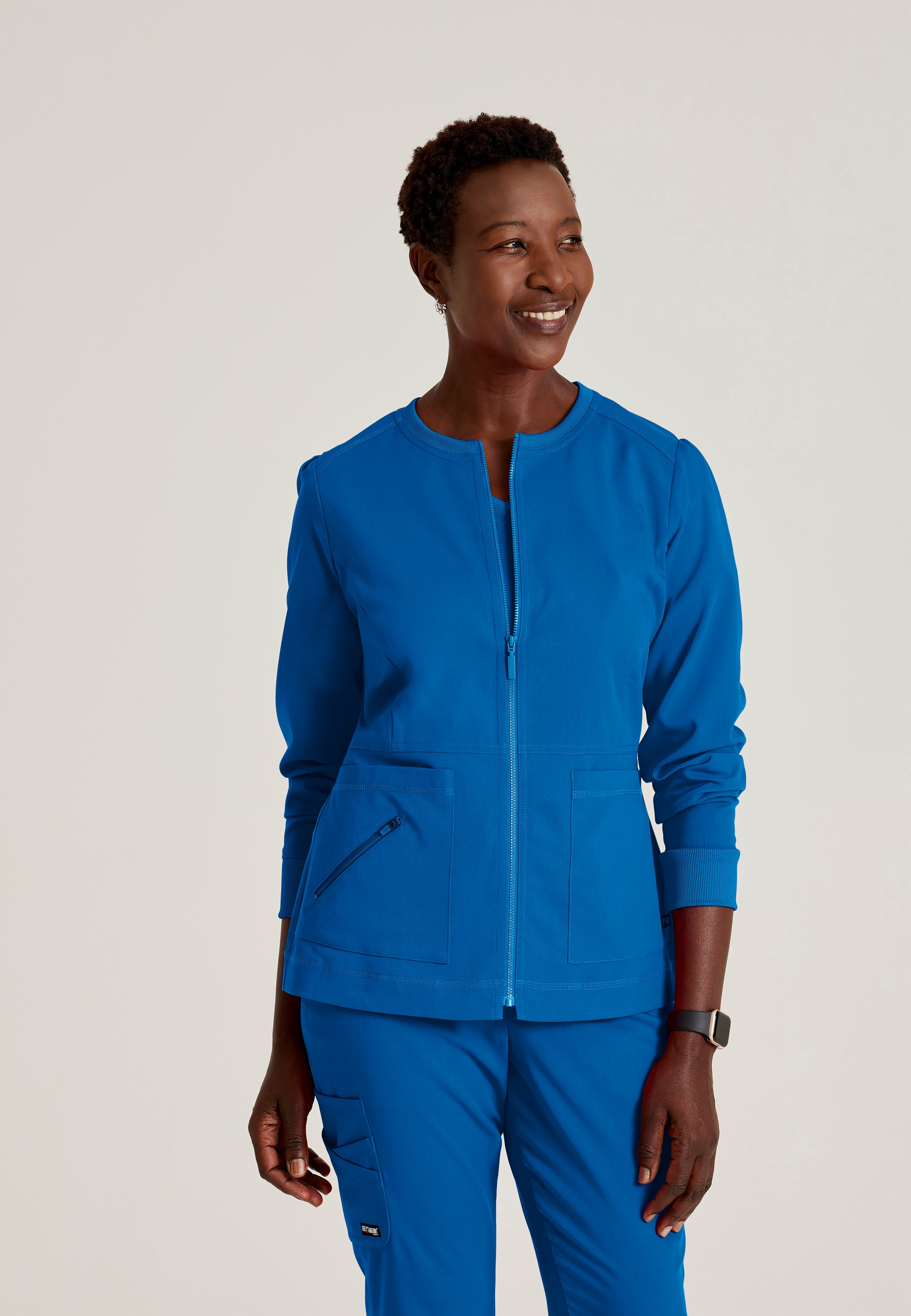 Front View of the Millie 3-Pocket Crewneck Scrub Jacket in New Royal from Grey's Anatomy™ by Barco Spandex Stretch