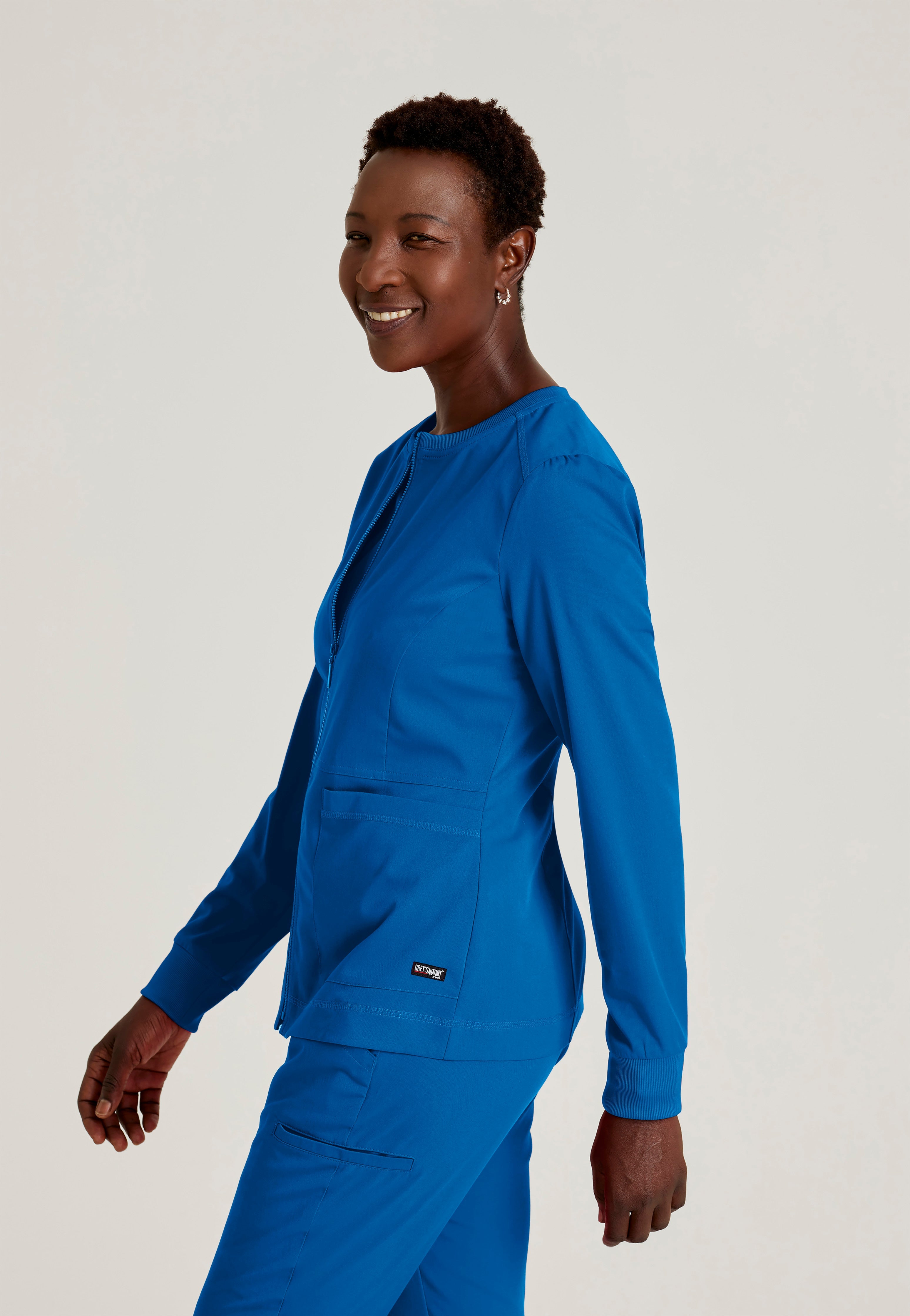 Side View of the Millie 3-Pocket Crewneck Scrub Jacket in New Royal from Grey's Anatomy™ by Barco Spandex Stretch