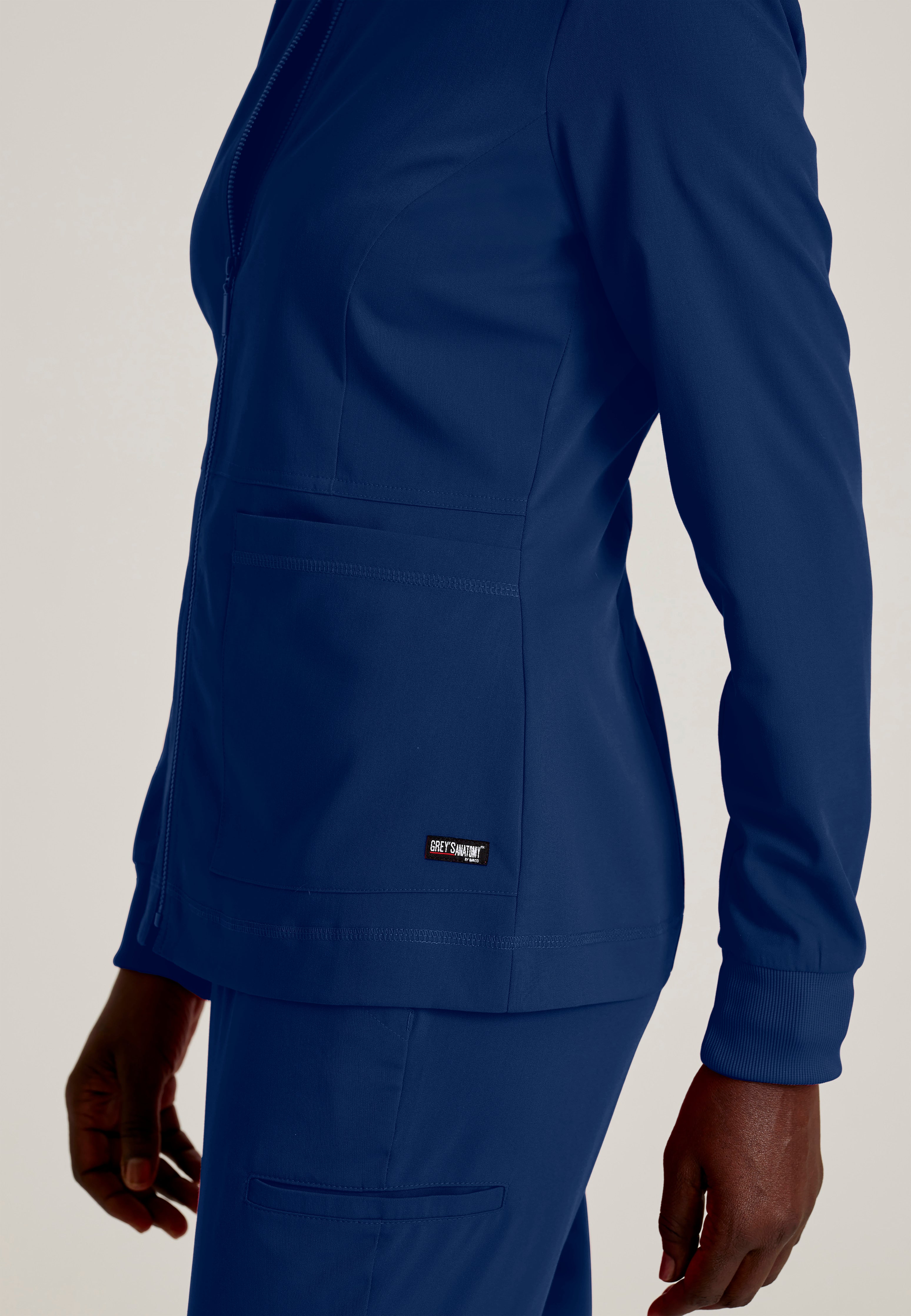 Detail Shot of the Millie 3-Pocket Crewneck Scrub Jacket in Indigo from Grey's Anatomy™ by Barco Spandex Stretch