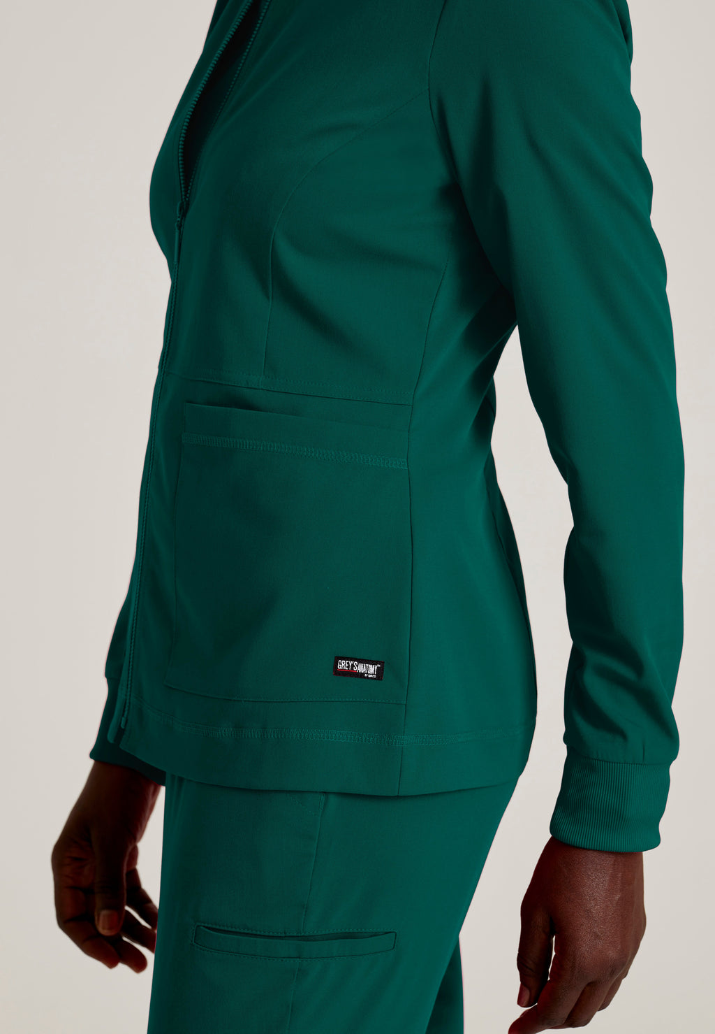 Detail Shot of the Millie 3-Pocket Crewneck Scrub Jacket in Hunter Green from Grey's Anatomy™ by Barco Spandex Stretch