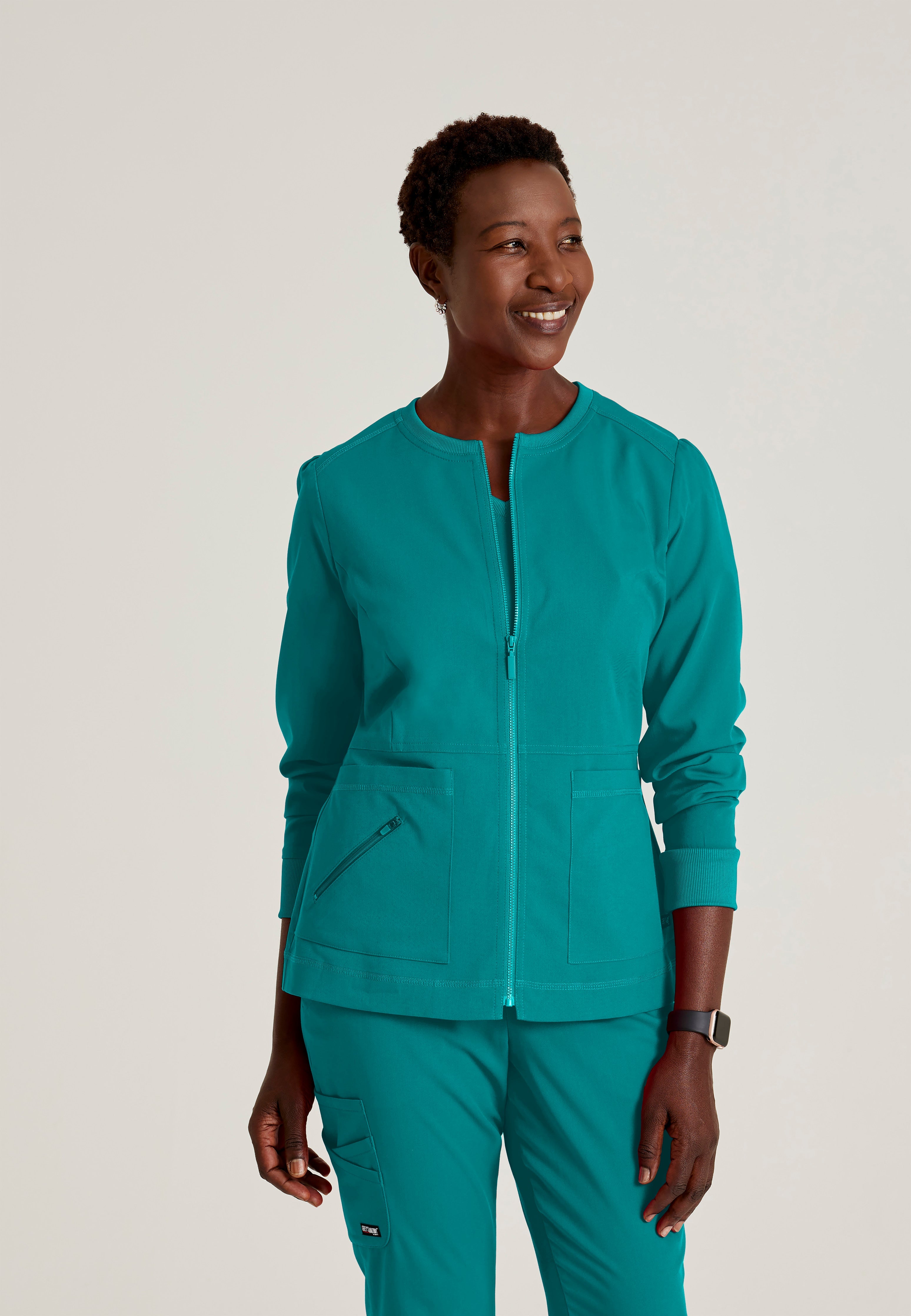 Front View of the Millie 3-Pocket Crewneck Scrub Jacket in Teal from Grey's Anatomy™ by Barco Spandex Stretch