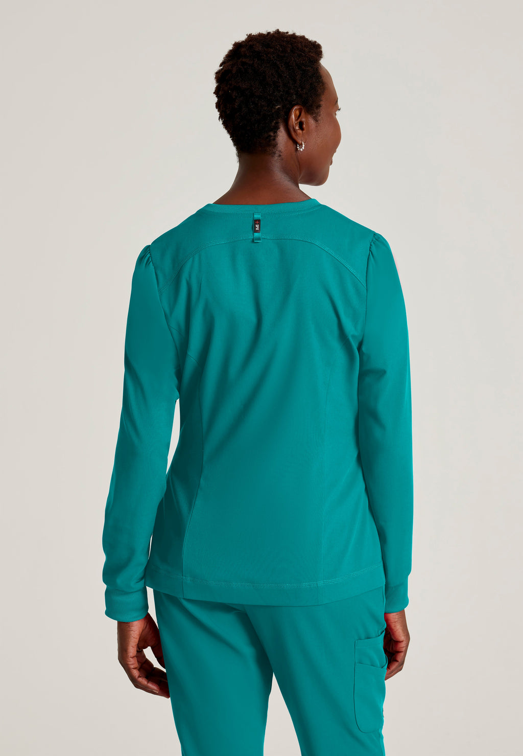 Back View of the Millie 3-Pocket Crewneck Scrub Jacket in Teal from Grey's Anatomy™ by Barco Spandex Stretch