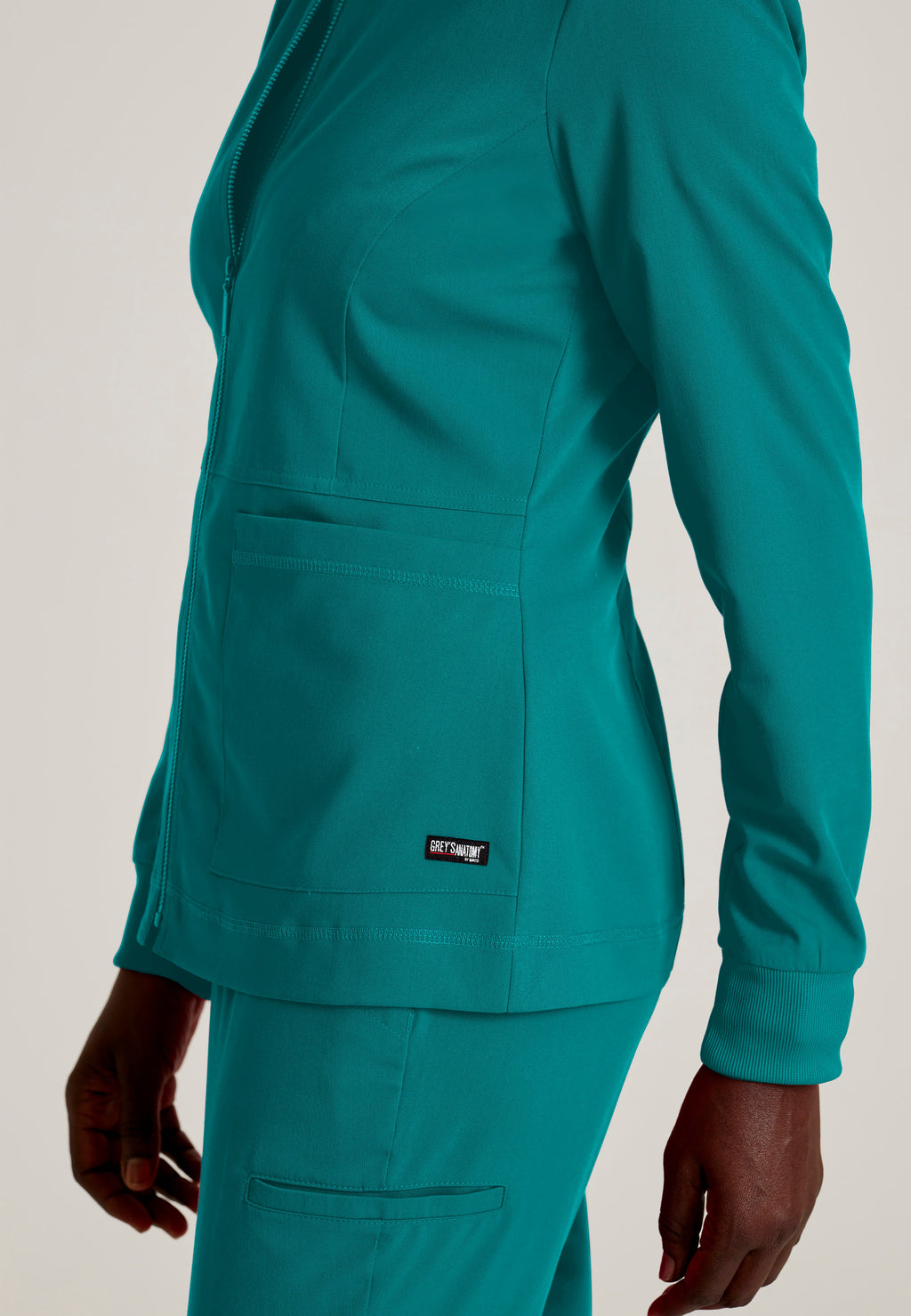 Detail Shot of the Millie 3-Pocket Crewneck Scrub Jacket in Teal from Grey's Anatomy™ by Barco Spandex Stretch