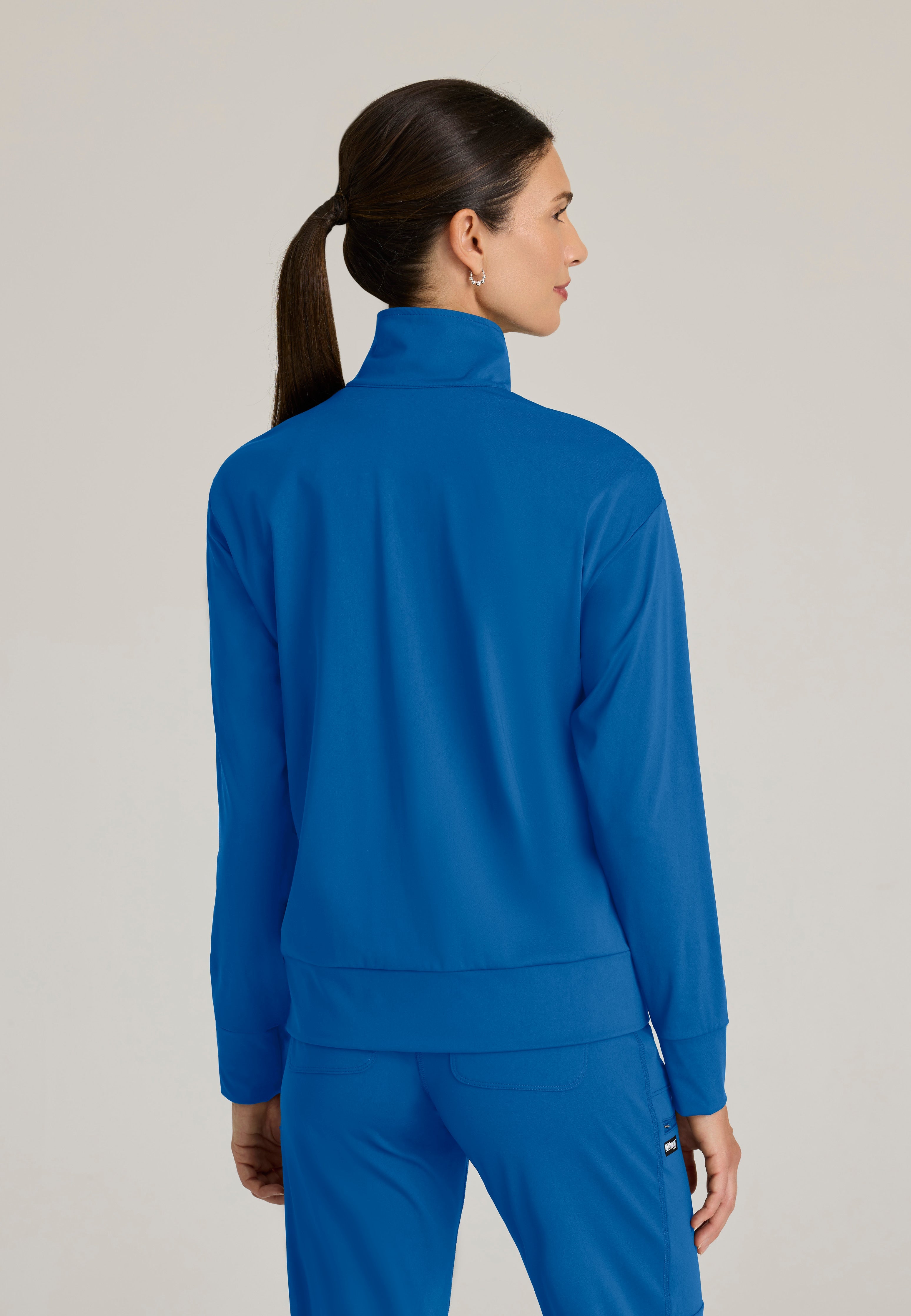 Back View of the Ease Knit Warm-Up Jacket in New Royal from Grey's Anatomy™ by Barco Knit Stretch