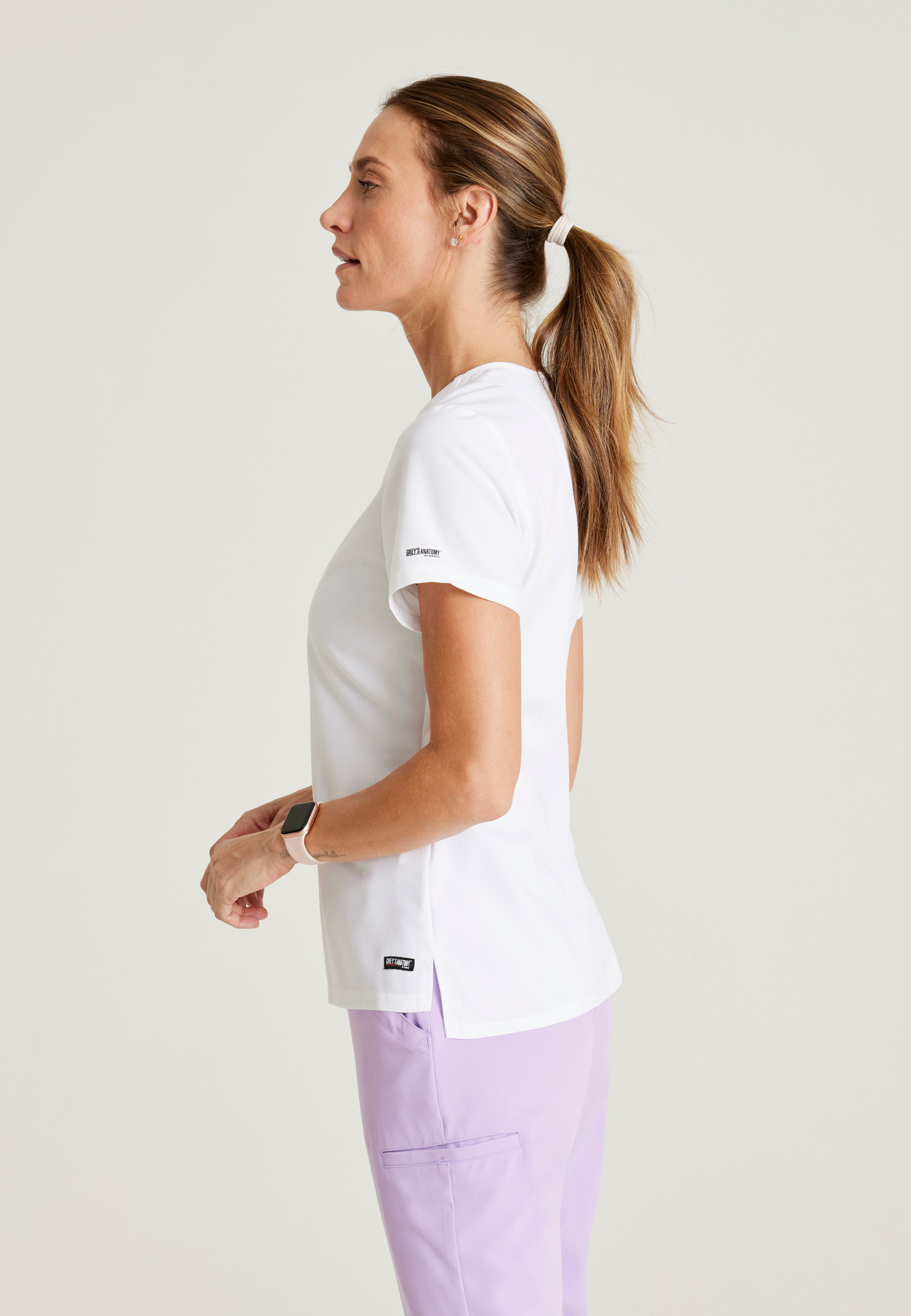 Side View of the Bree 1-Pocket Tuck-In Scrub Top in White from Grey's Anatomy™ by Barco Spandex Stretch