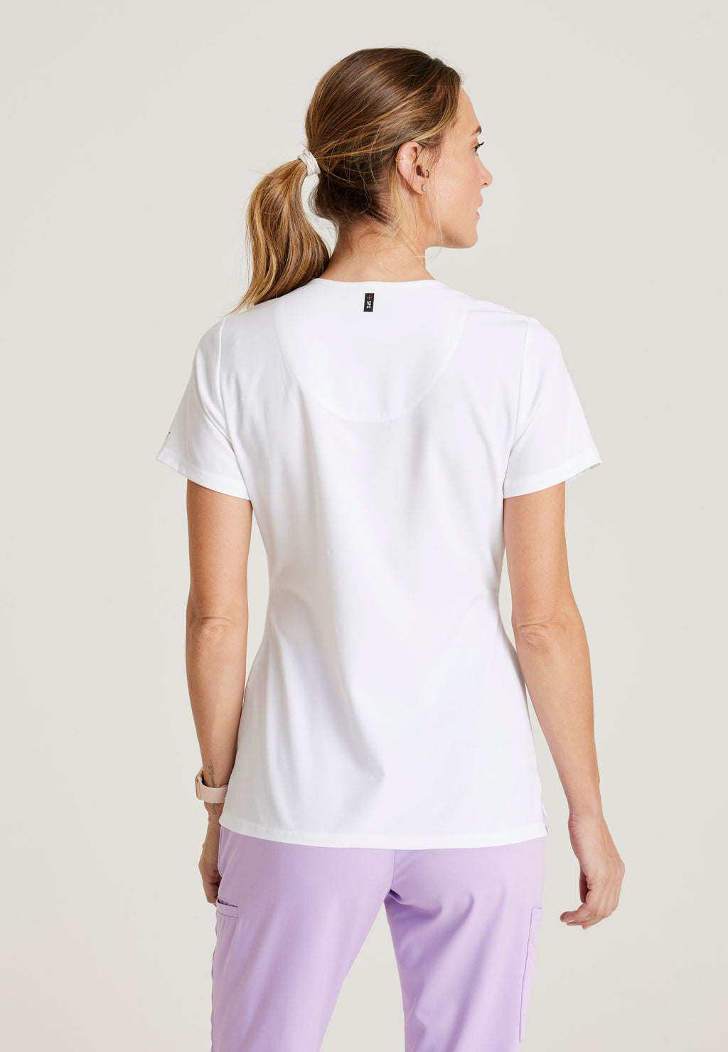 Back View of the Bree 1-Pocket Tuck-In Scrub Top in White from Grey's Anatomy™ by Barco Spandex Stretch