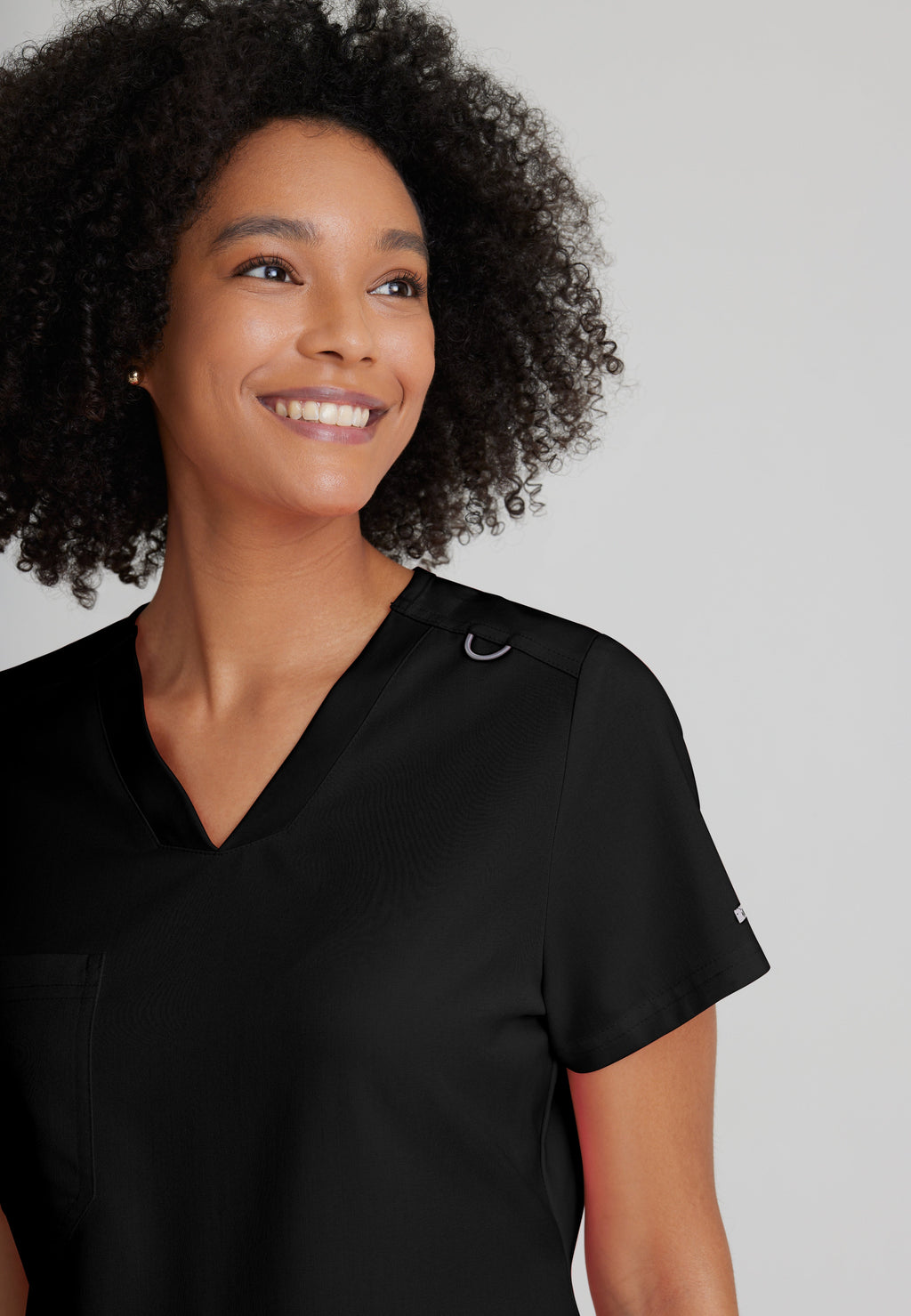 Detail Shot of the Bree 1-Pocket Tuck-In Scrub Top in Black from Grey's Anatomy™ by Barco Spandex Stretch