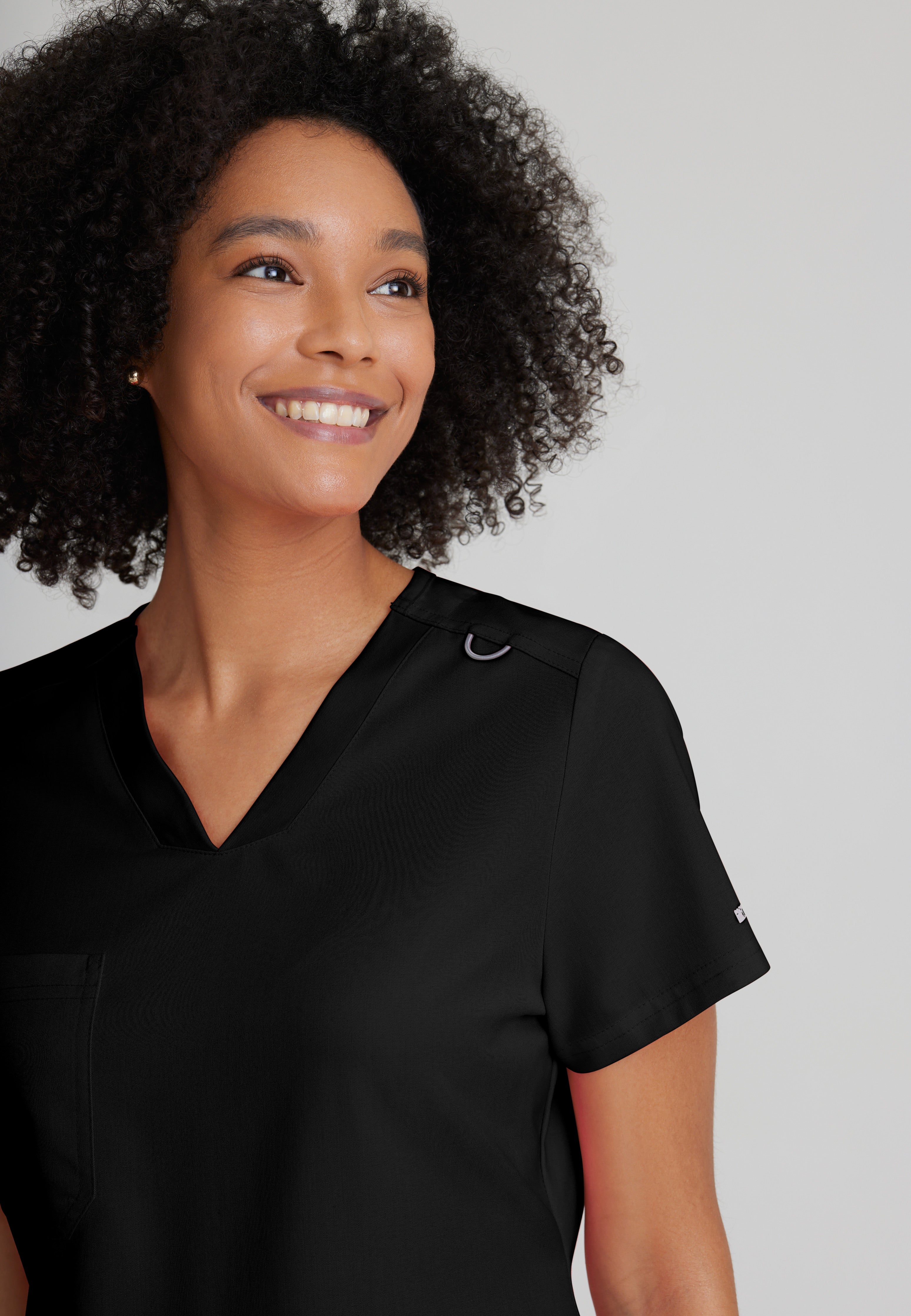Detail Shot of the Bree 1-Pocket Tuck-In Scrub Top in Black from Grey's Anatomy™ by Barco Spandex Stretch