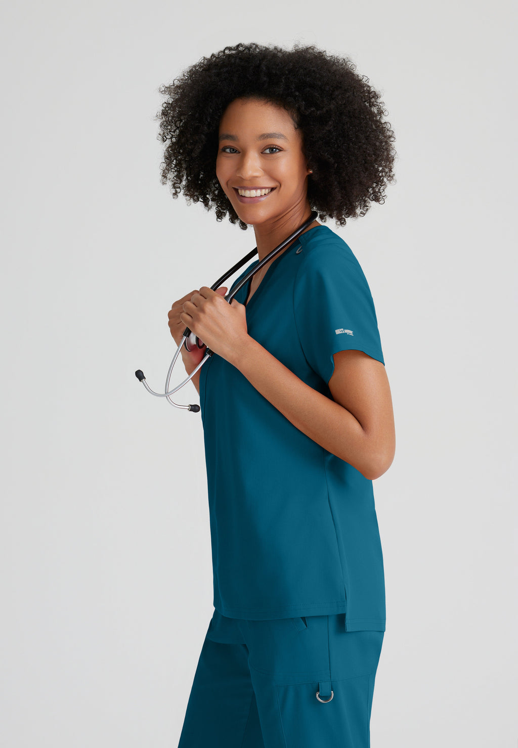 Side View of the Bree 1-Pocket Tuck-In Scrub Top in Bahama from Grey's Anatomy™ by Barco Spandex Stretch