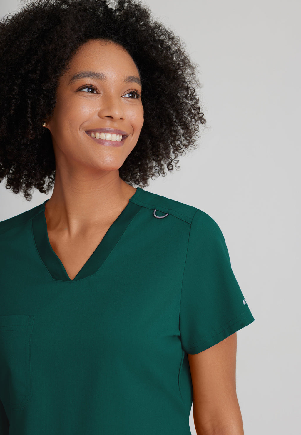 Detail Shot of the Bree 1-Pocket Tuck-In Scrub Top in Hunter Green from Grey's Anatomy™ by Barco Spandex Stretch