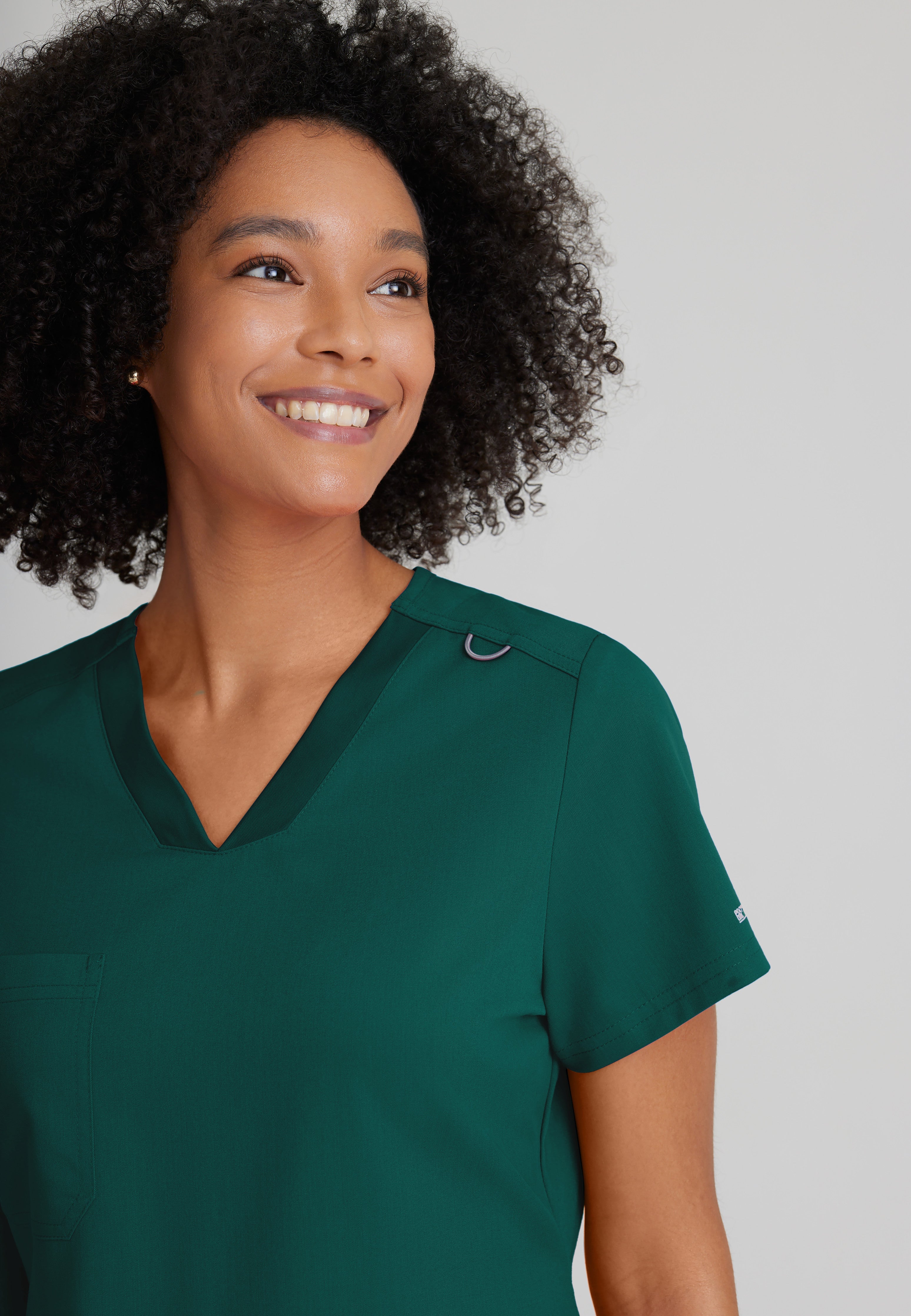 Detail Shot of the Bree 1-Pocket Tuck-In Scrub Top in Hunter Green from Grey's Anatomy™ by Barco Spandex Stretch