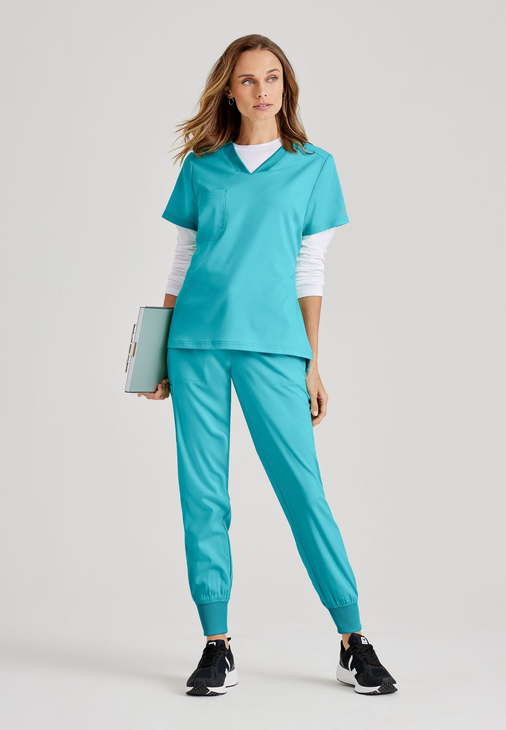 Grey's Anatomy Spandex-Stretch women's teal V-neck scrub top. Chest pocket. Badge loop. Split hem. Moisture-wicking stretch fabric.