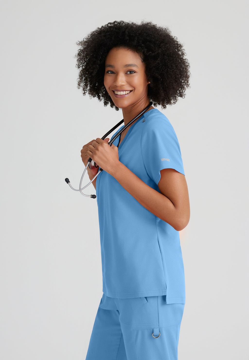 Side View of the Bree 1-Pocket Tuck-In Scrub Top in Ciel Blue from Grey's Anatomy™ by Barco Spandex Stretch