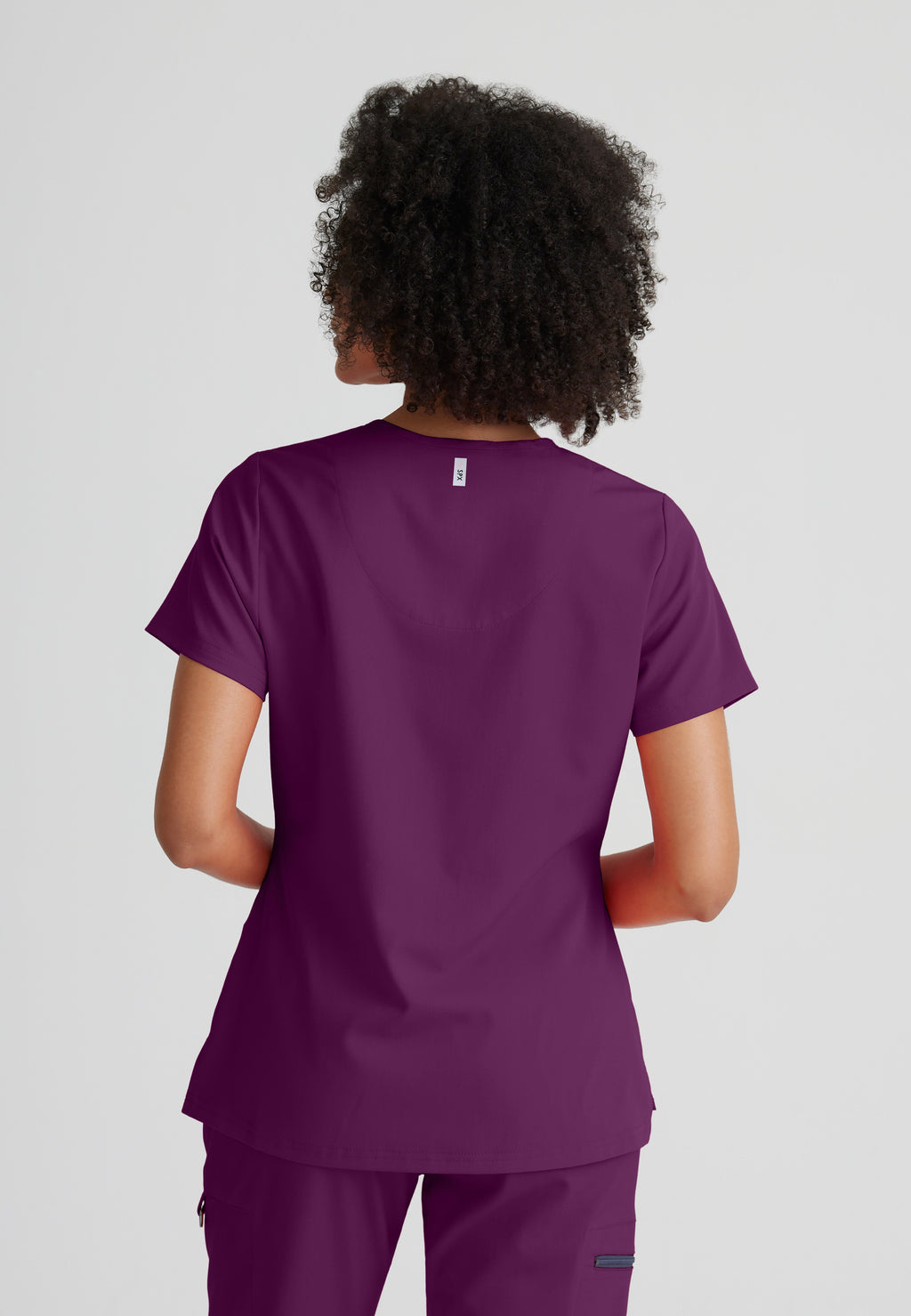 Back View of the Bree 1-Pocket Tuck-In Scrub Top in Wine from Grey's Anatomy™ by Barco Spandex Stretch